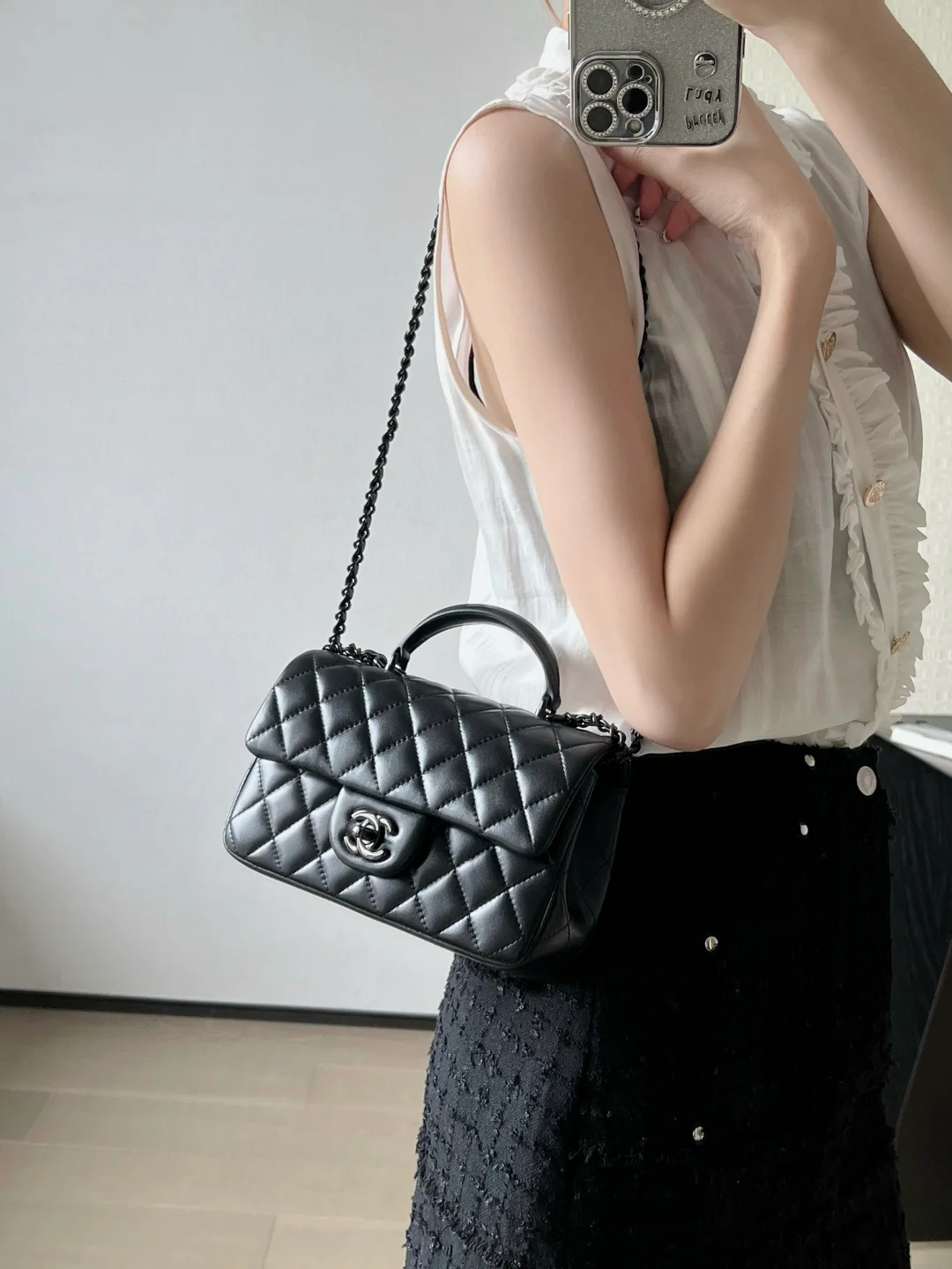 Мини-сумочка Chanel 25p-CF с клапаном — черная с черной пряжкой.