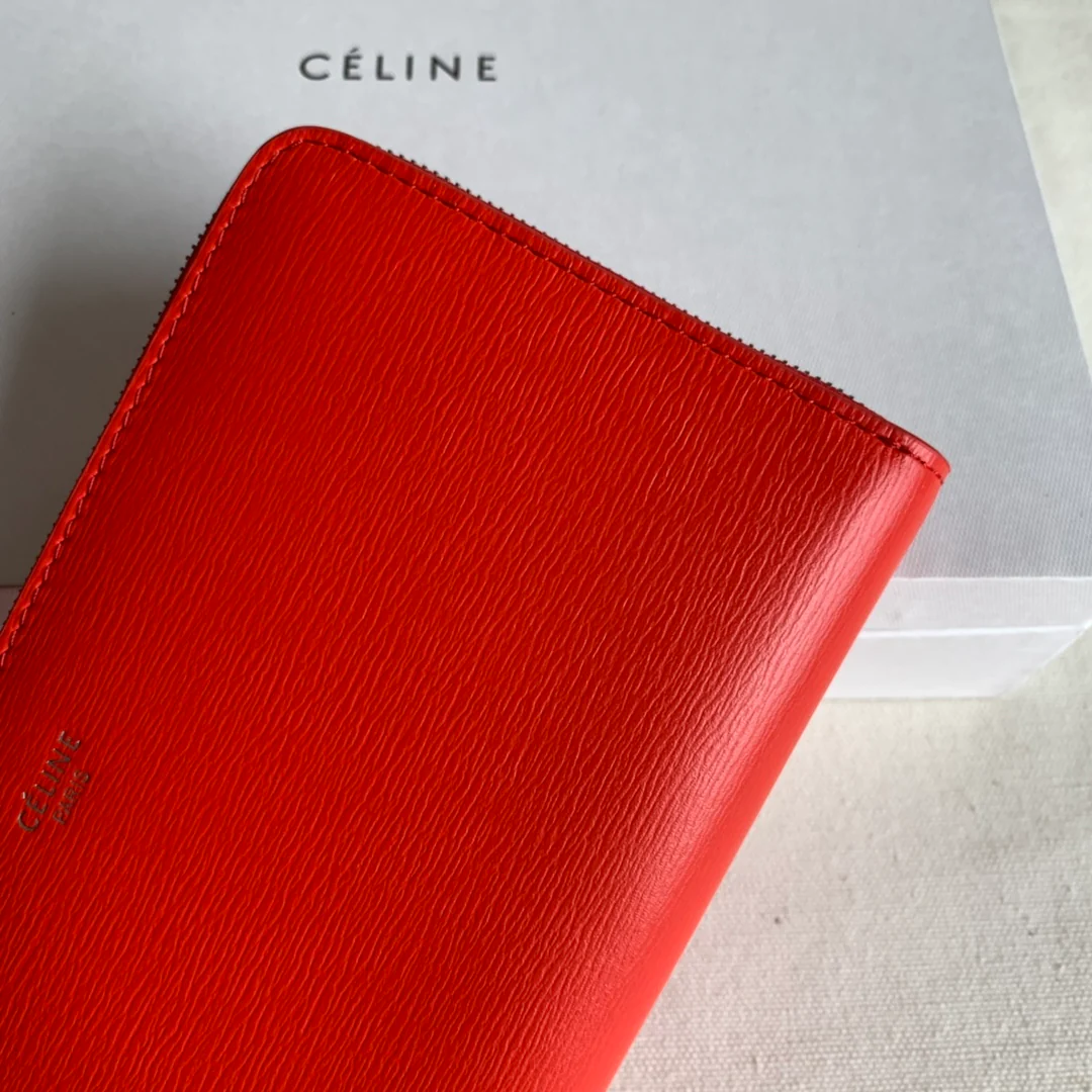 Кошелек Celine с длинной молнией — оранжево-красный узор в виде ряби на воде.