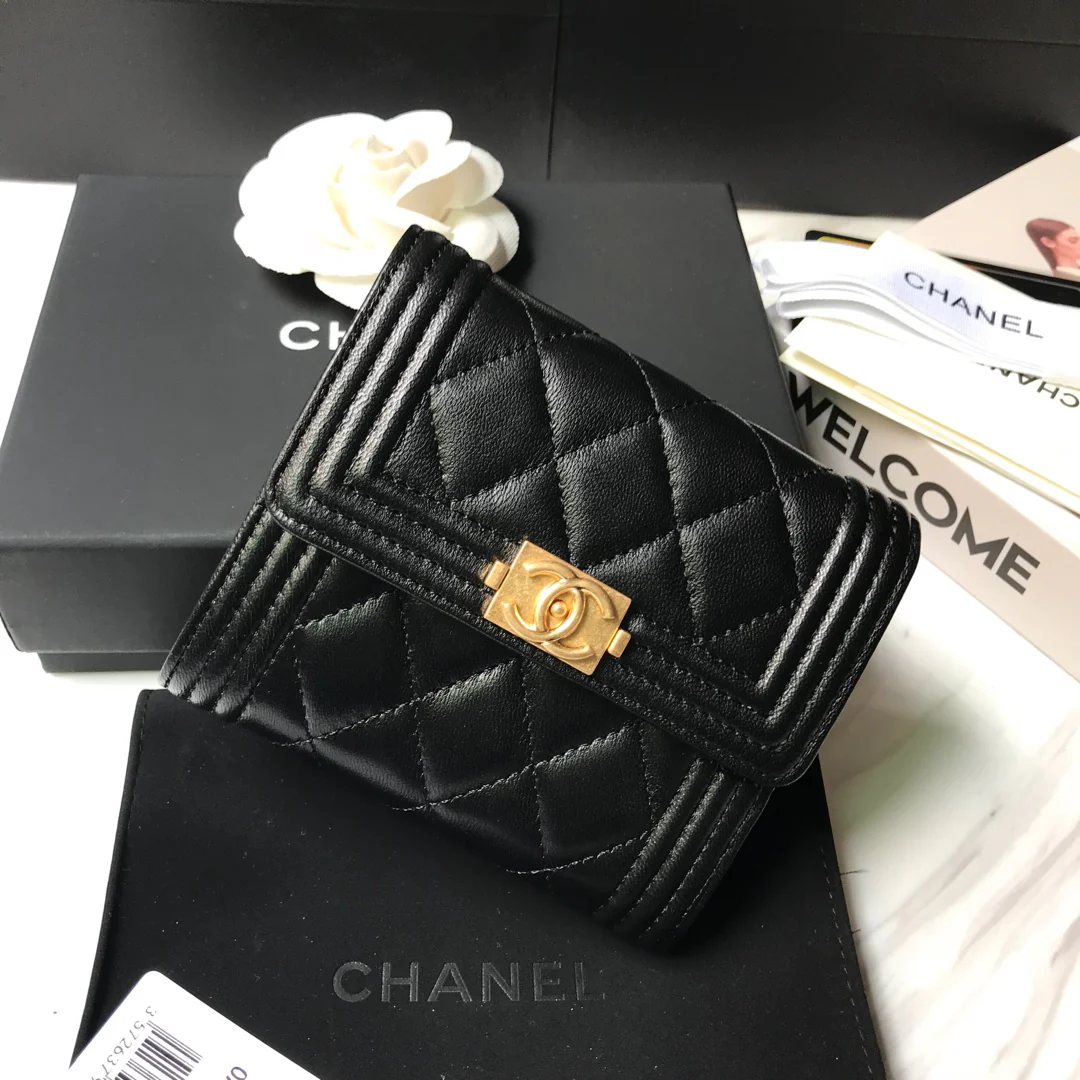 Кошелек Chanel Le Boy Tri-fold Wallet — из черной овечьей кожи с золотой пряжкой.