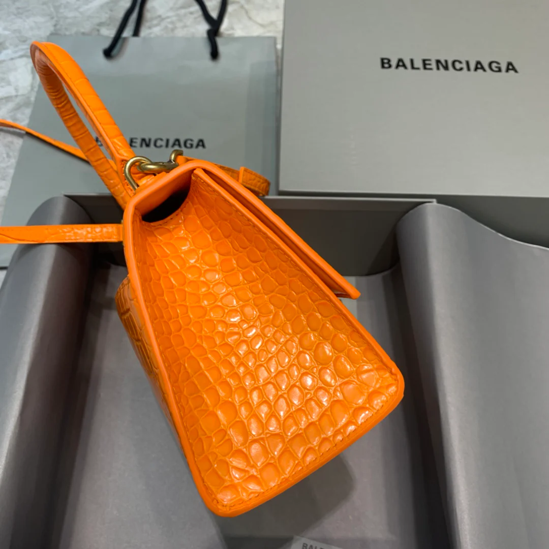 Сумка Balenciaga Hourglass — оранжевая с тиснением под крокодиловую кожу и золотой пряжкой.