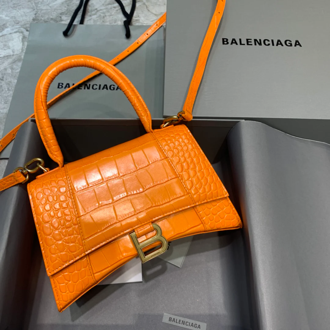 Сумка Balenciaga Hourglass — оранжевая с тиснением под крокодиловую кожу и золотой пряжкой.
