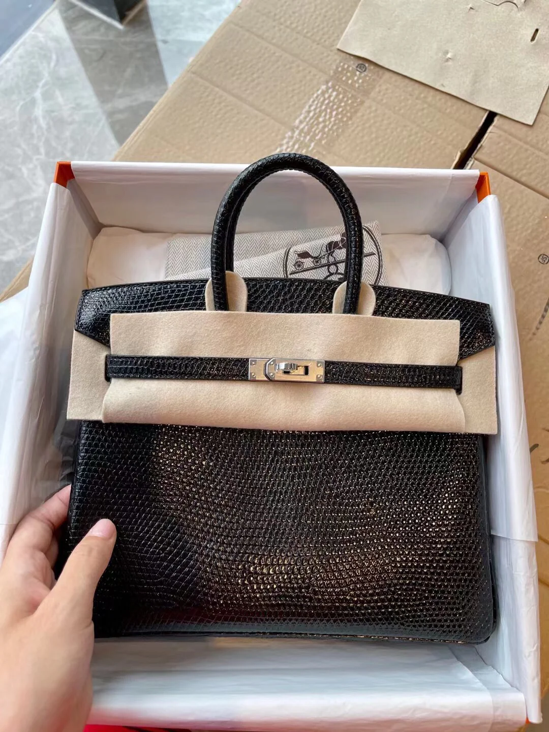 Сумка Hermes Birkin 25 из кожи ящерицы, черная, с серебряной пряжкой.