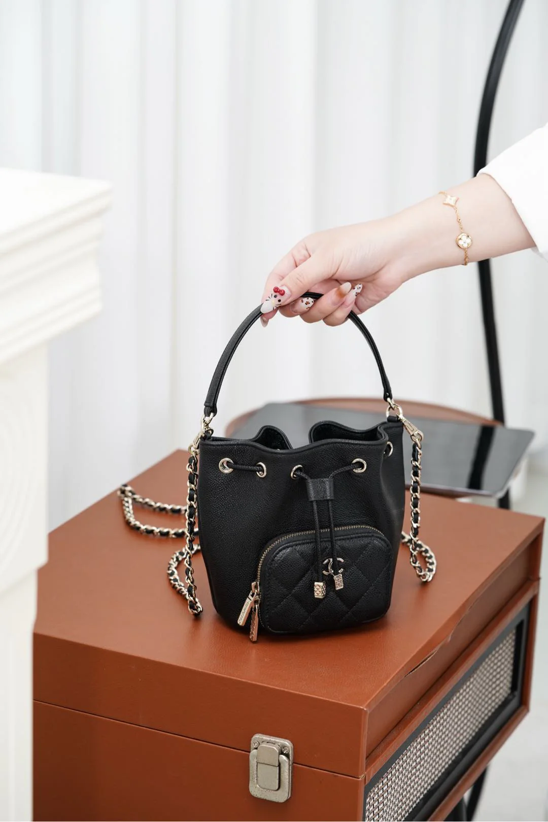 Миниатюрная черная сумка-ведро Chanel 25b с цепочкой и завязками.