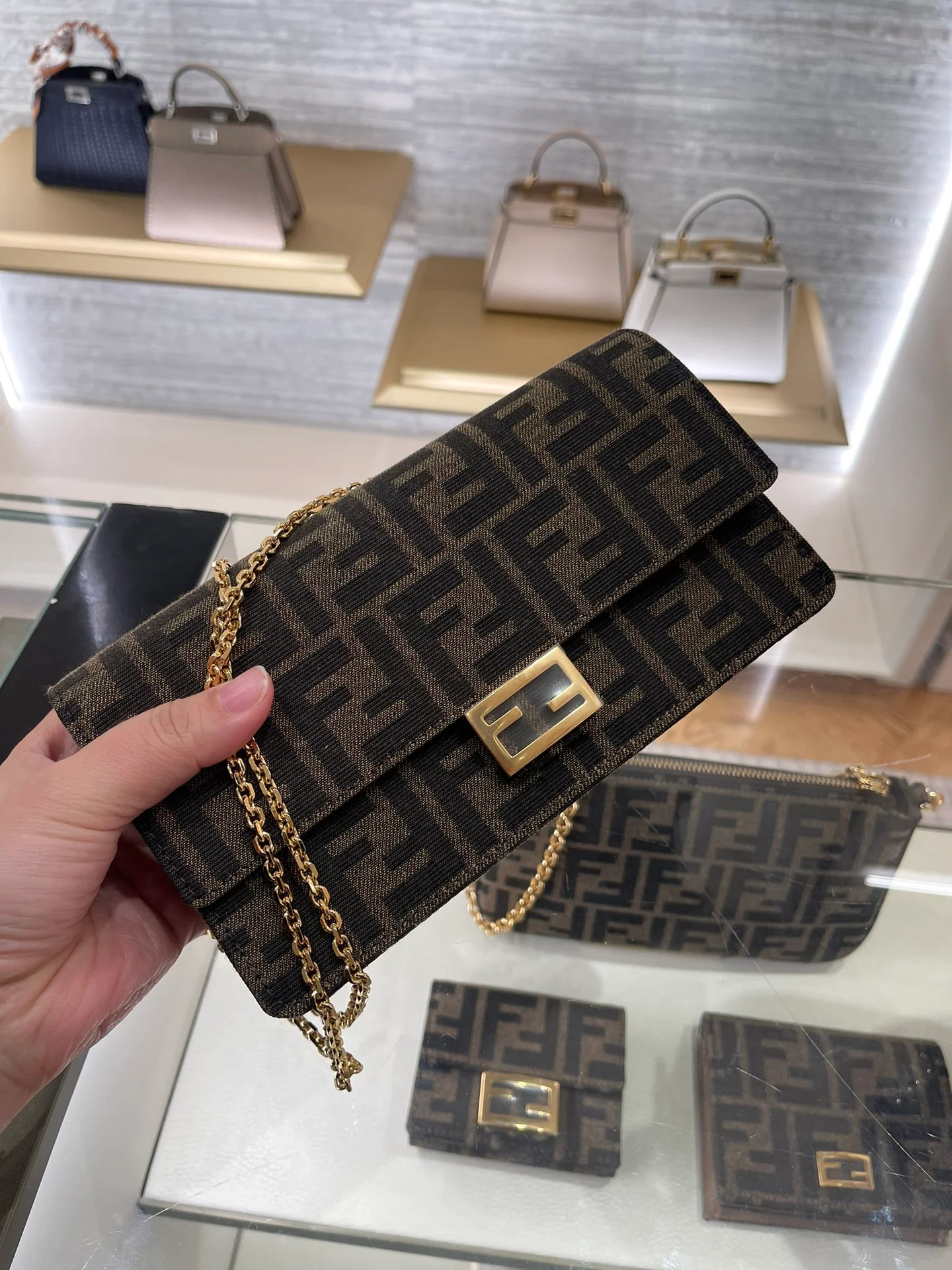 Сумка Fendi с монограммой и цепочкой под мышкой