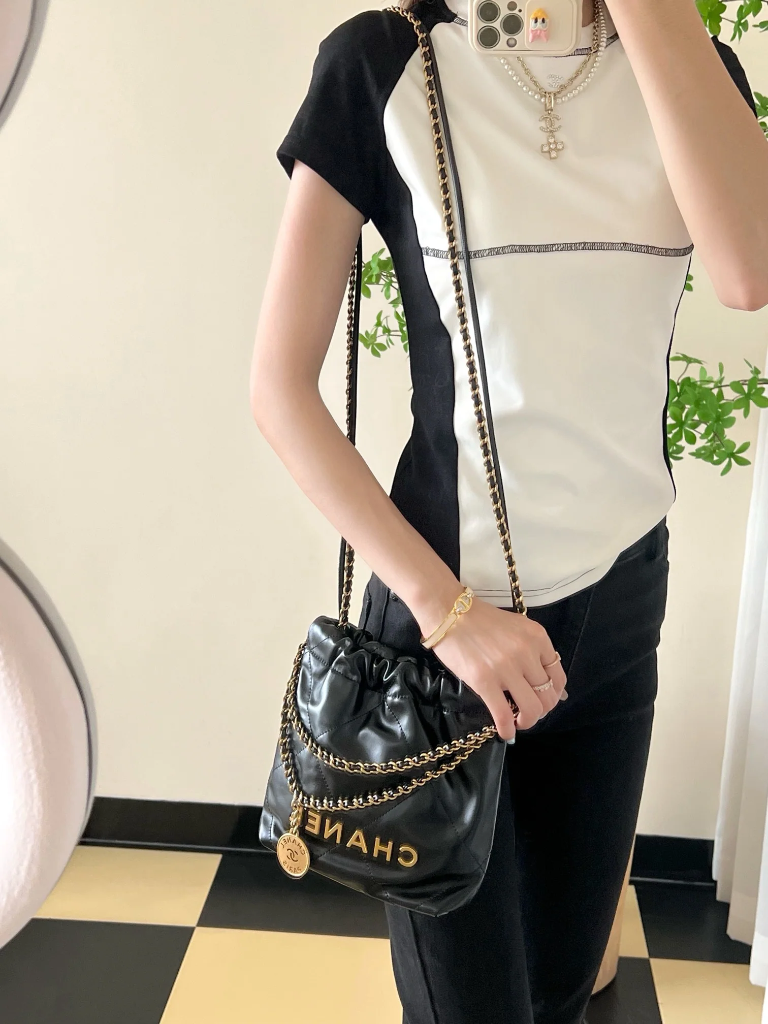 Мини-сумочка Chanel 22 – черная с золотой фурнитурой.