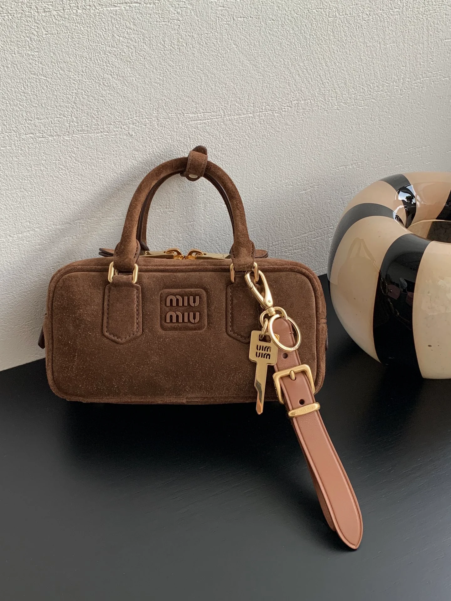 Сумка-боулинг Miu Miu из замши, маленькая, коричневая, излучает роскошь при ношении.