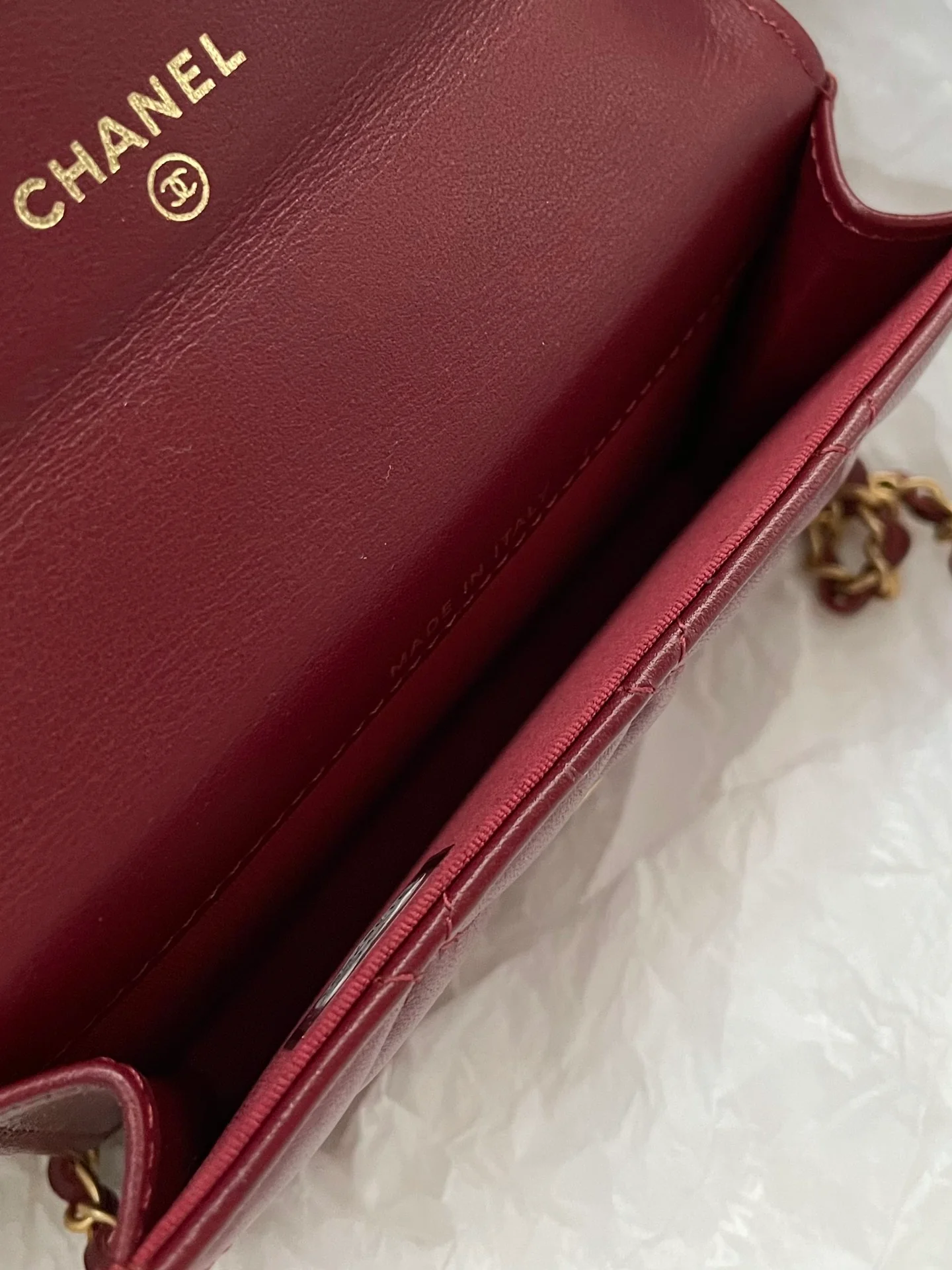 Держатель для карт Chanel с двойной золотой цепочкой и шариками, отделанный бордовой кожей.