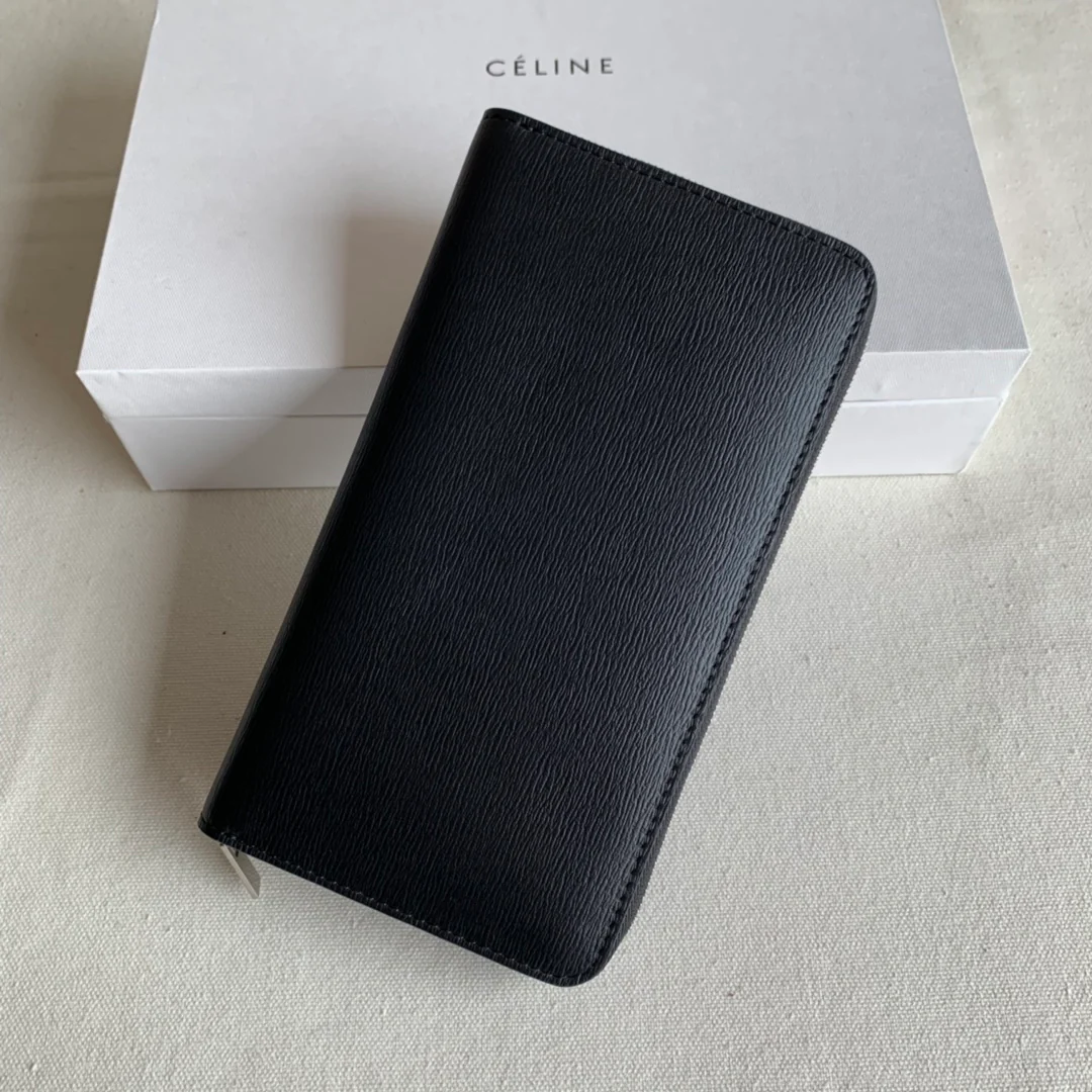 Длинный кошелек Celine на молнии — черный с узором в виде ряби на воде.