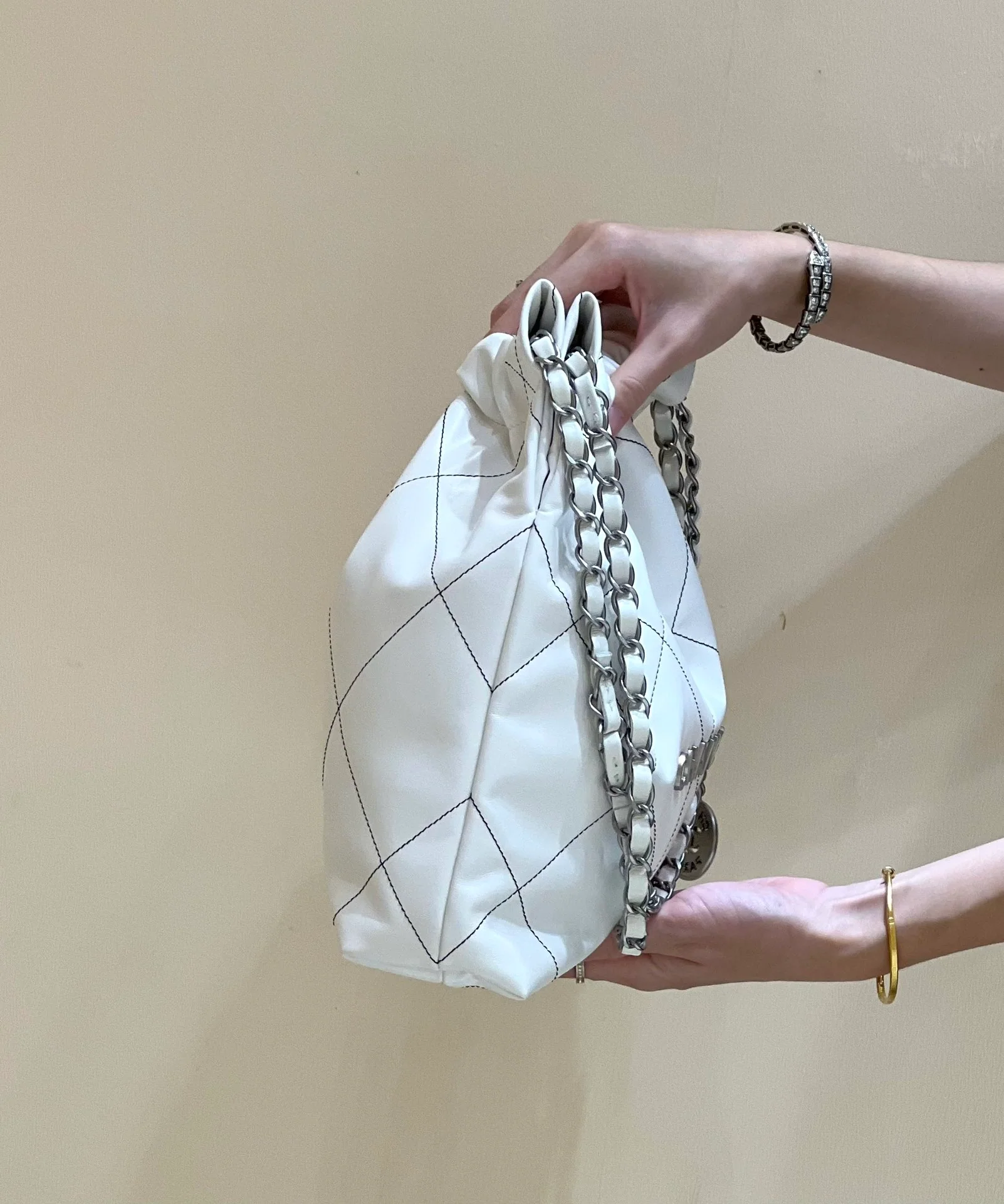 Сумка Chanel из круизной коллекции 2023 года - модель 22bag - белая с черной строчкой.