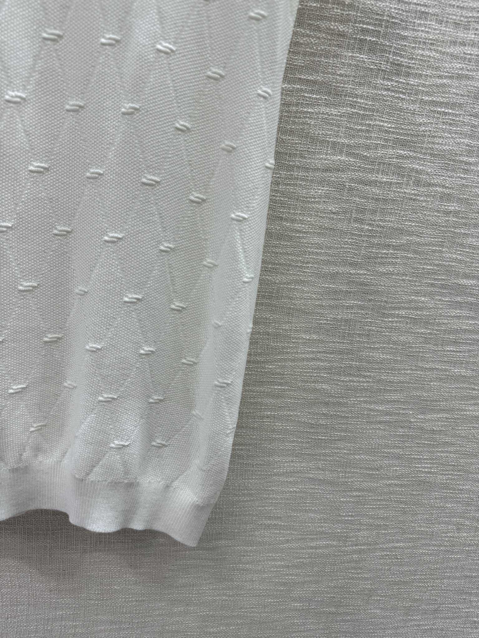 Новая коллекция Chanel Весна/Лето 2024: трикотажное платье с короткими рукавами и ромбовидным узором, белое.