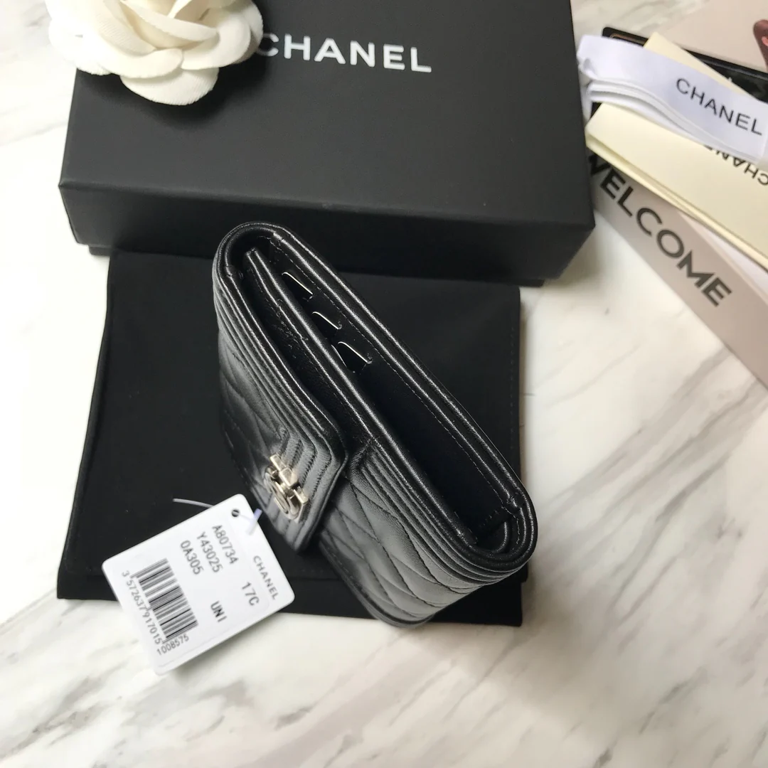 Кошелек Chanel Le Boy Tri-fold Wallet — из черной овечьей кожи с серебряной пряжкой.