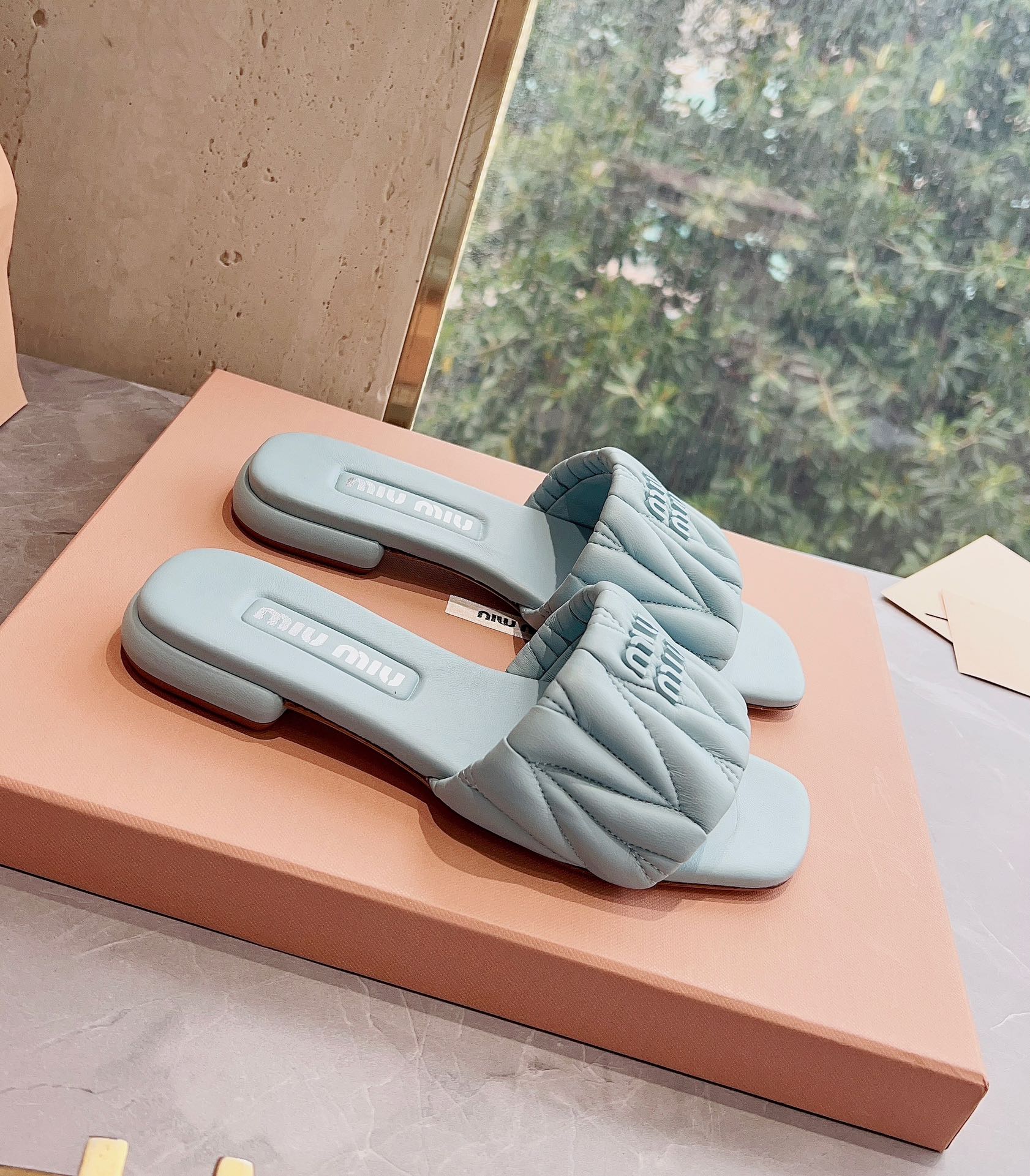 Новинка сезона весна/лето 2023 от Miu Miu - плоские тапочки из овечьей кожи - светло-серые.