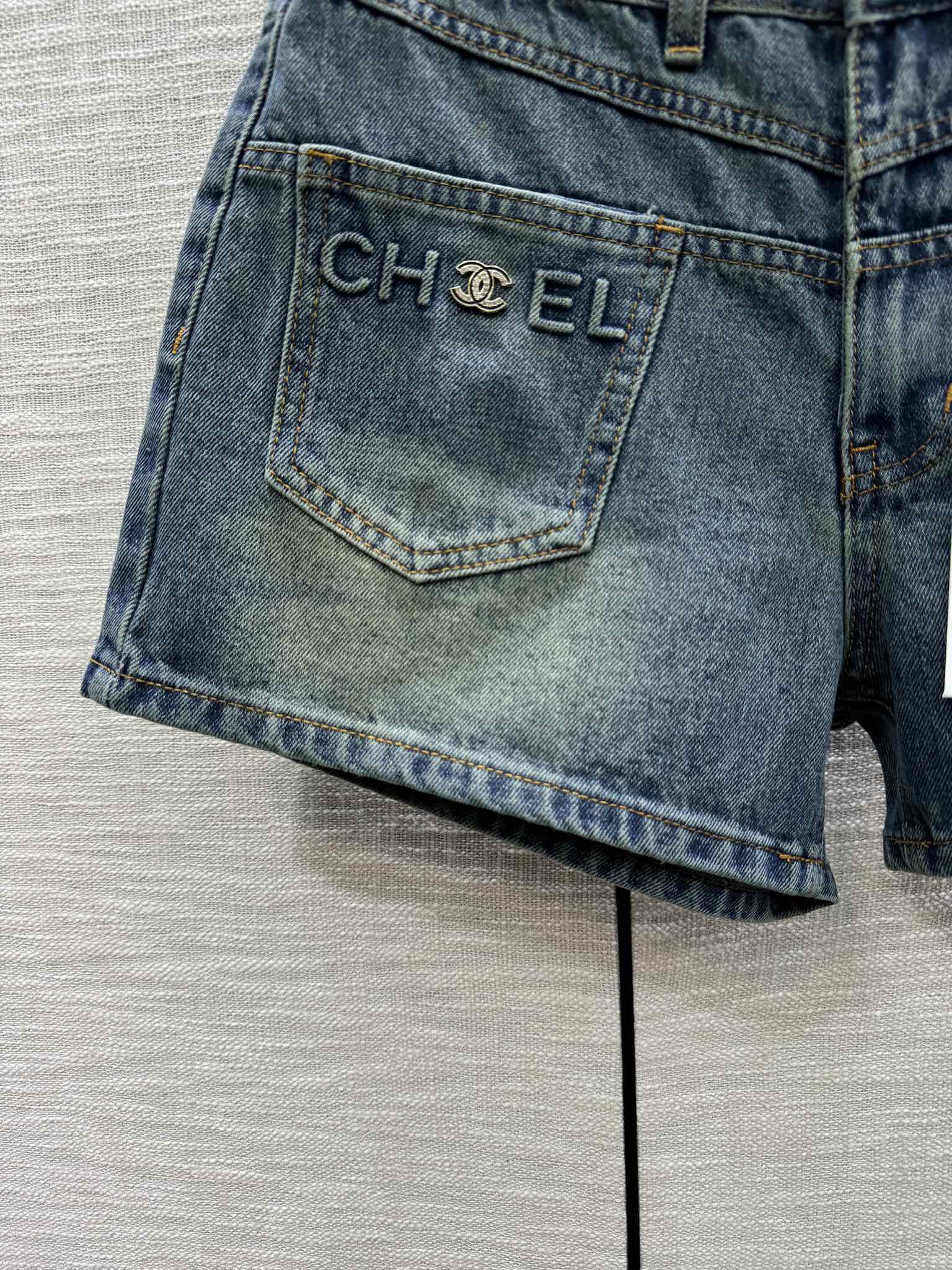 Джинсовые шорты Chanel 2403 с высокой талией и двумя карманами.