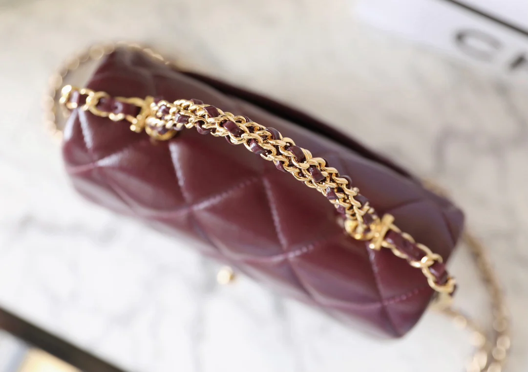 Маленькая бордовая сумочка Chanel с клапаном и привинчивающейся ручкой.