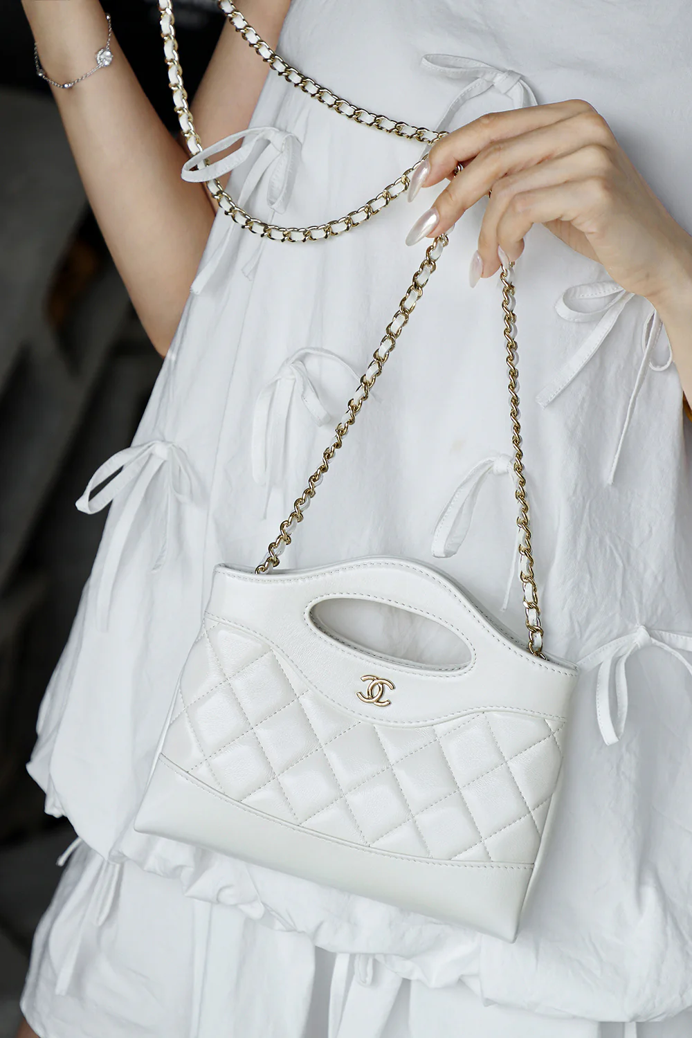 Сумка Chanel Nano 31, горизонтальный вариант, белая с пряжкой из светло-золотистого металла.