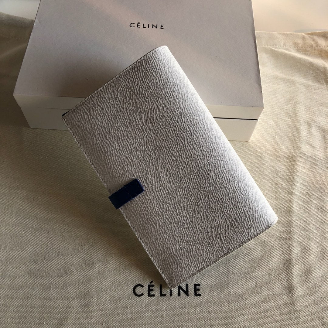 Длинный кошелек Celine — кремовый и синий — с принтом в виде пальмовых листьев.
