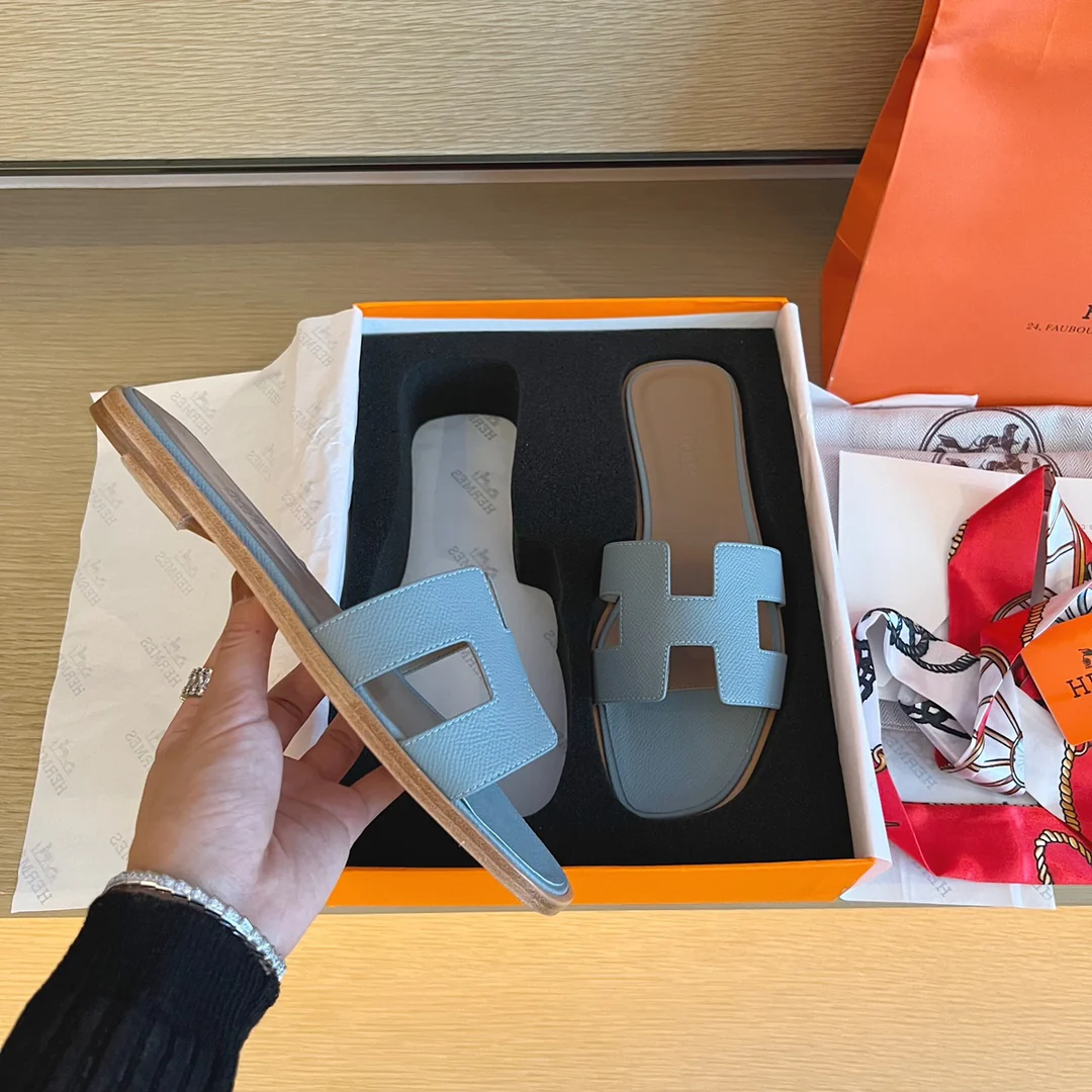 Классические тапочки Hermes с буквой H — светло-голубые с принтом пальм.