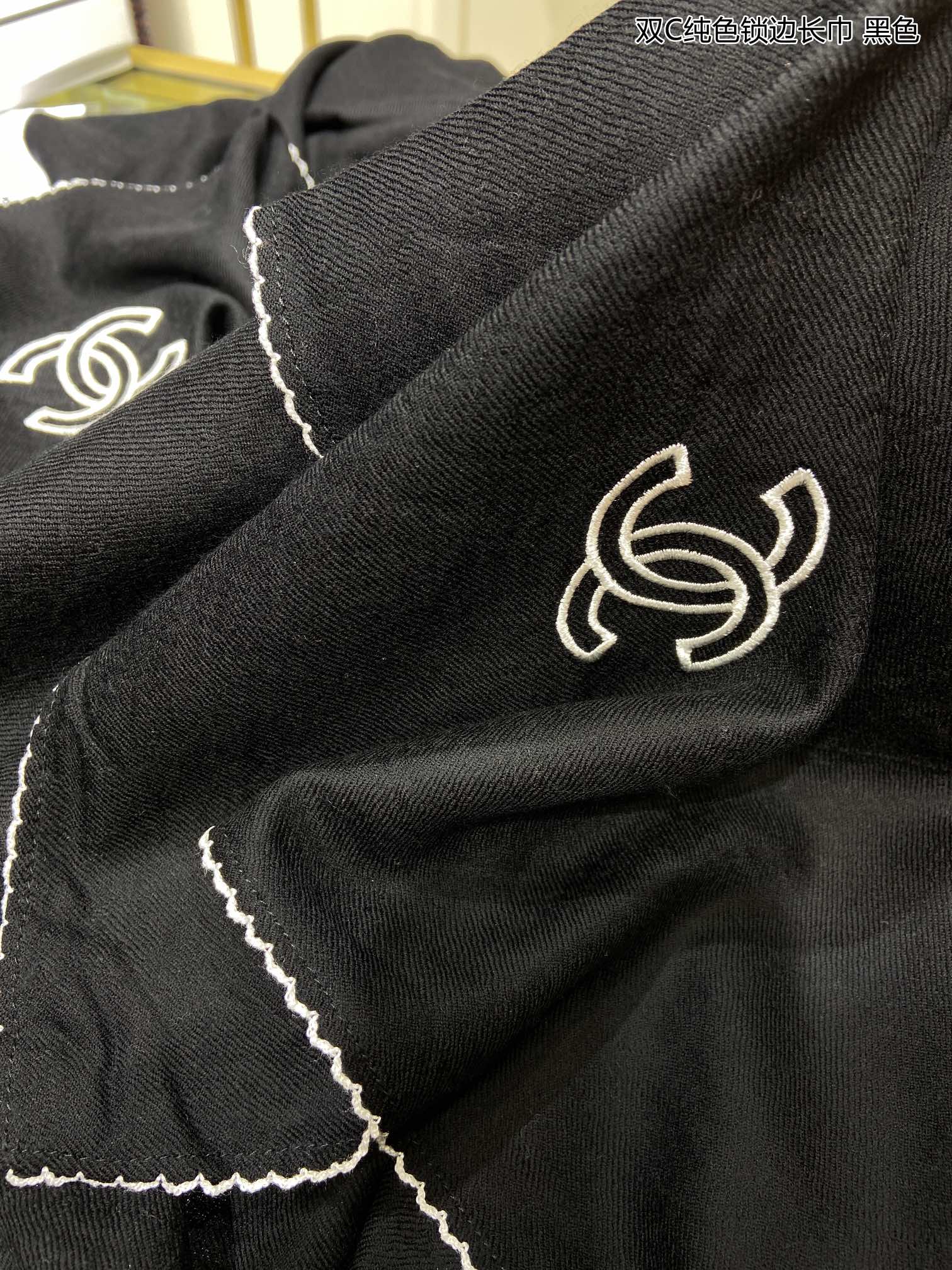 Однотонный кашемировый шарф Chanel с оверлочной отделкой.