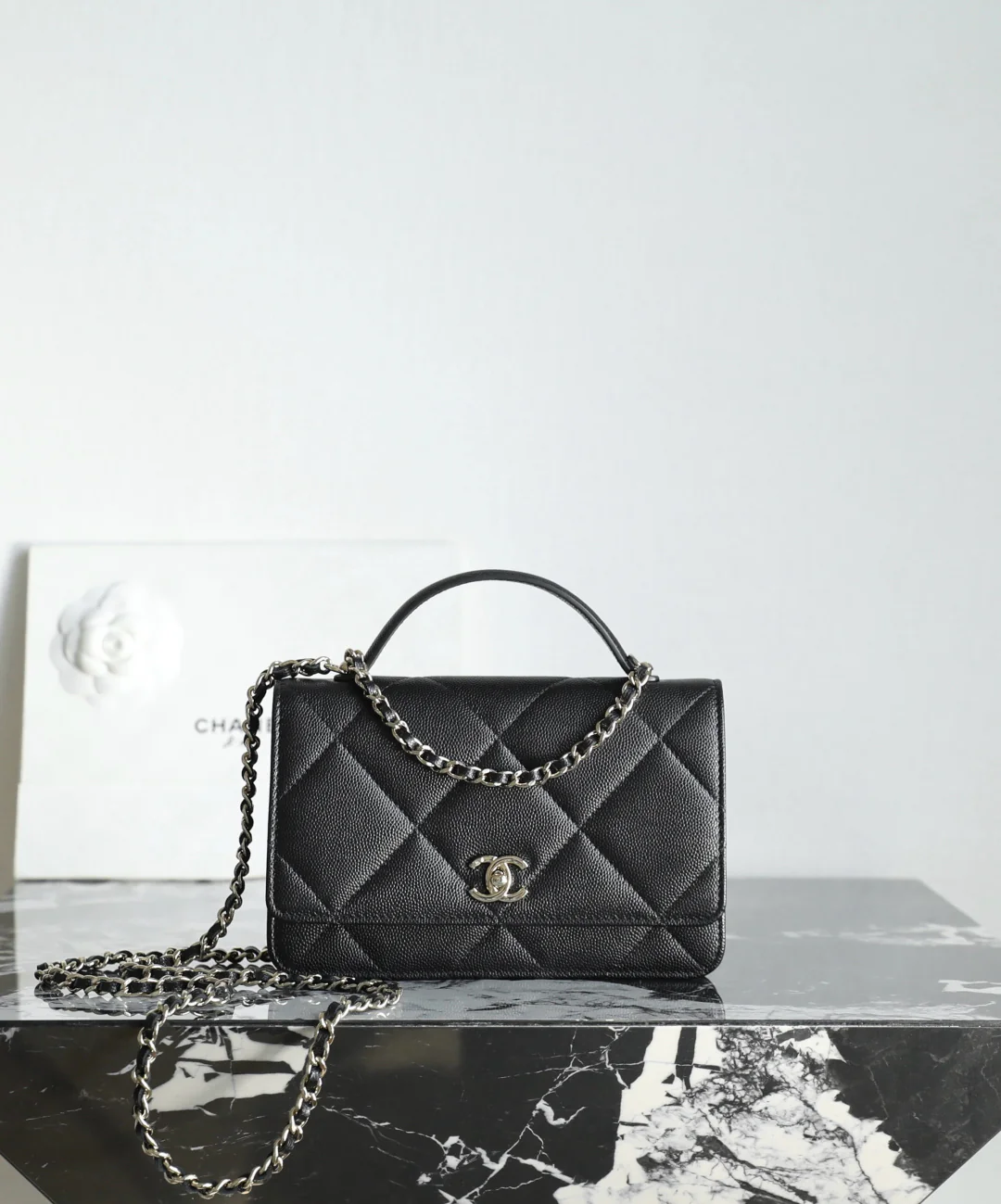 Сумка Chanel WOC с цепочкой и стеганой отделкой из 25-каратного золота — черная с фурнитурой из светлого золота.