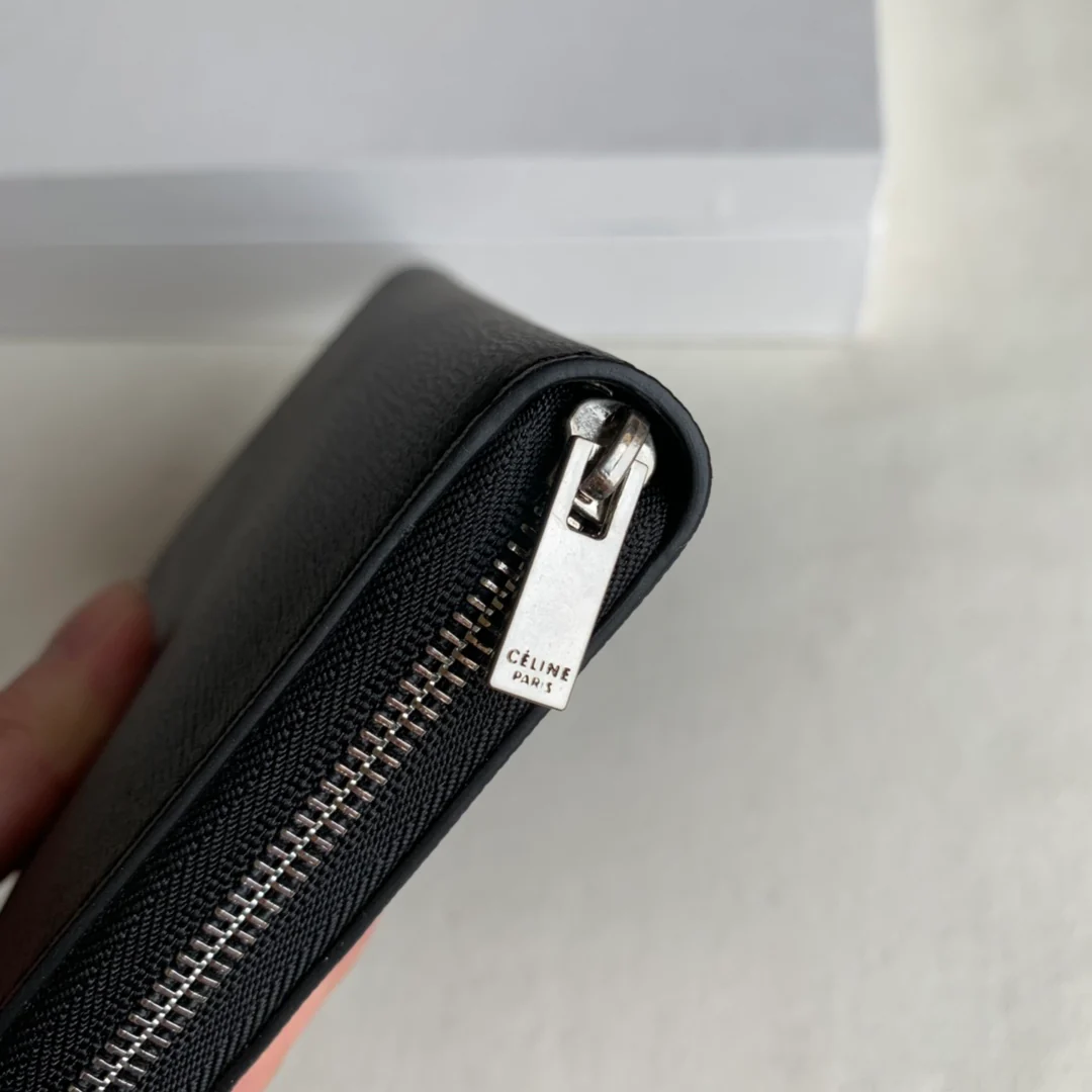 Длинный кошелек Celine на молнии — черный с узором в виде ряби на воде.