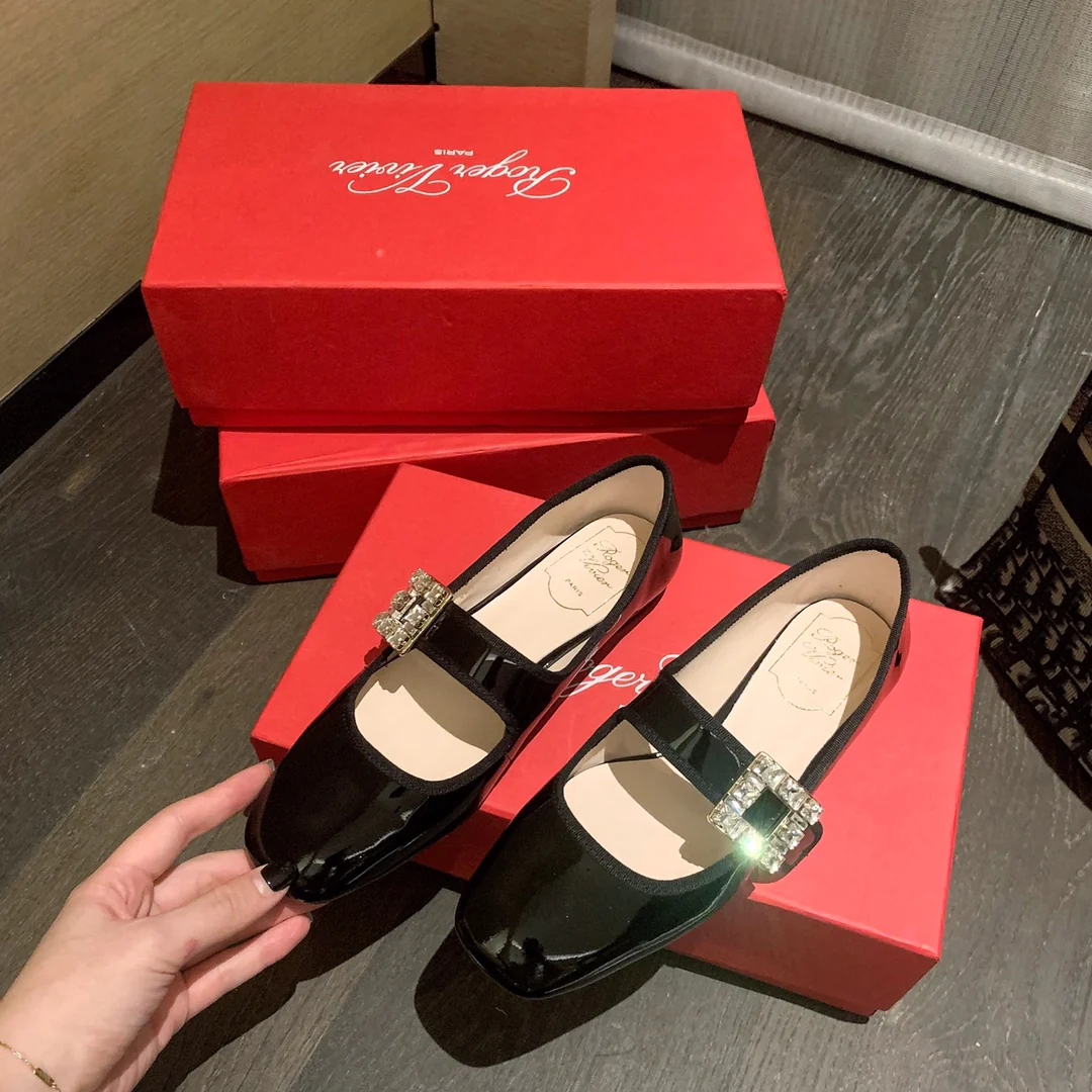 Лакированные балетки с пряжками, украшенными стразами — черные.