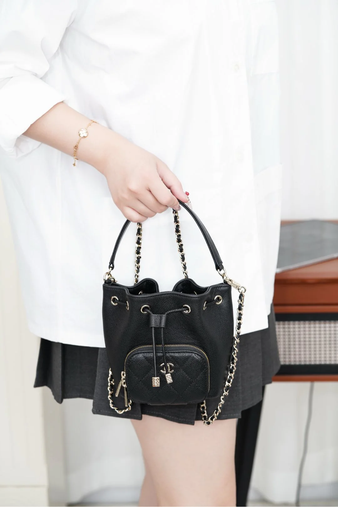 Миниатюрная черная сумка-ведро Chanel 25b с цепочкой и завязками.