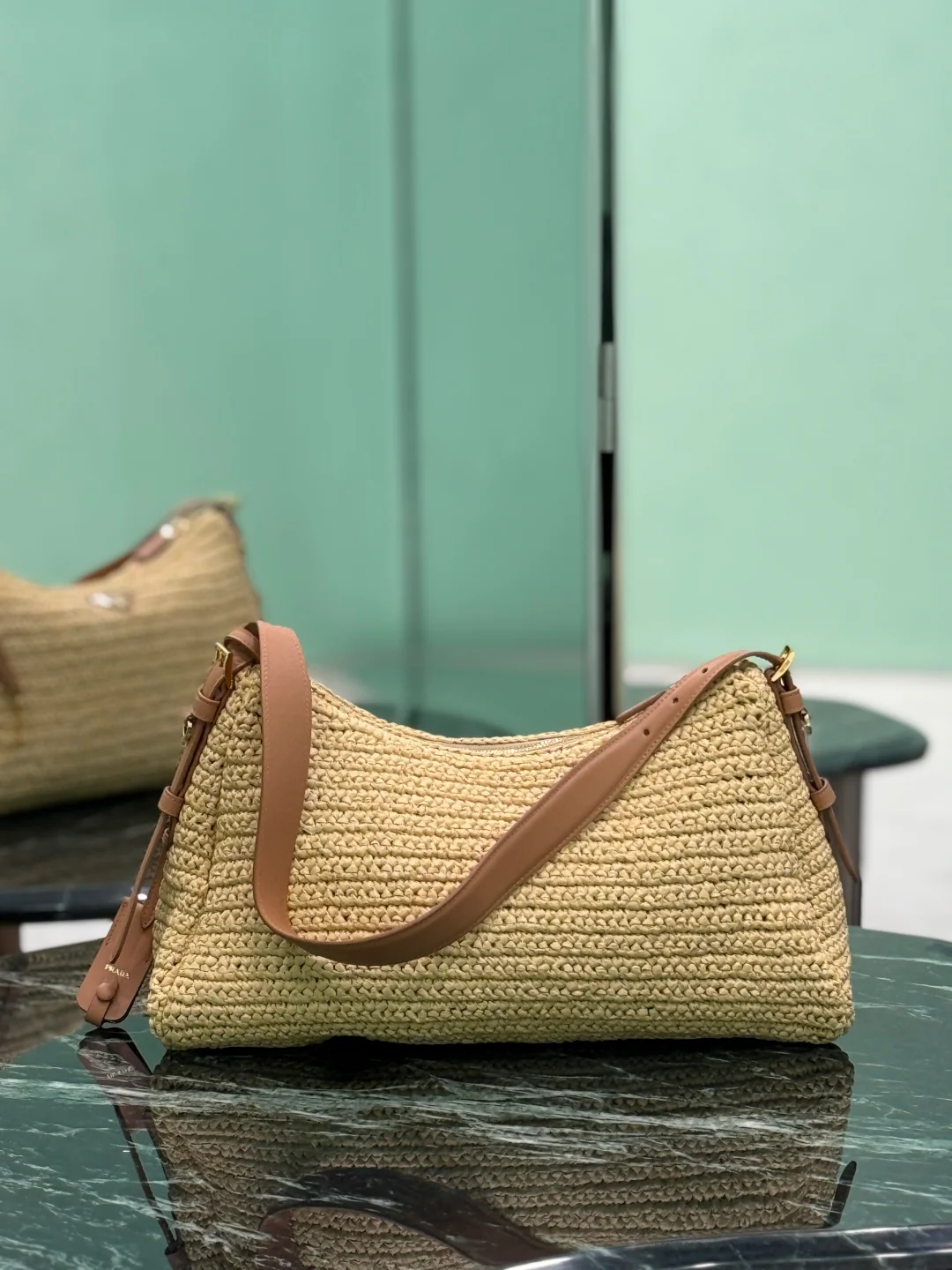 Сумка Prada Aimee из соломы, которую можно носить под мышкой.