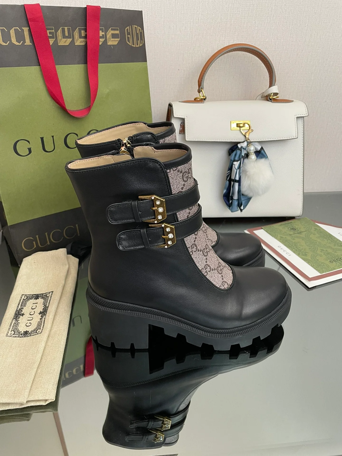 Сапоги Gucci на массивном каблуке до середины икры с монограммой — черные и бежевые.