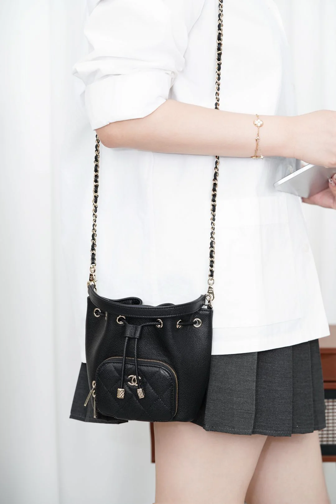 Миниатюрная черная сумка-ведро Chanel 25b с цепочкой и завязками.