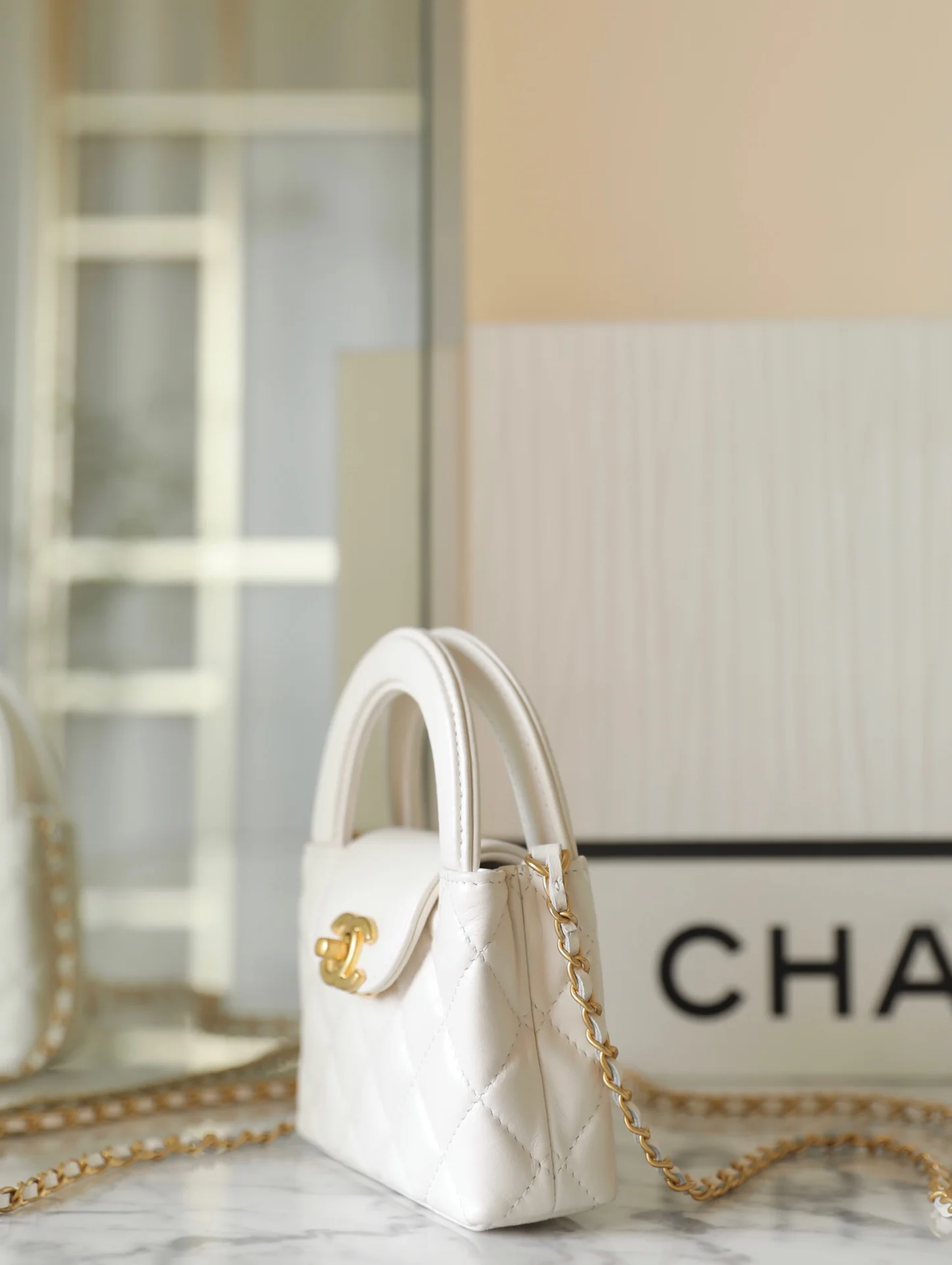 Миниатюрная сумочка Chanel Kelly на цепочке, белая.