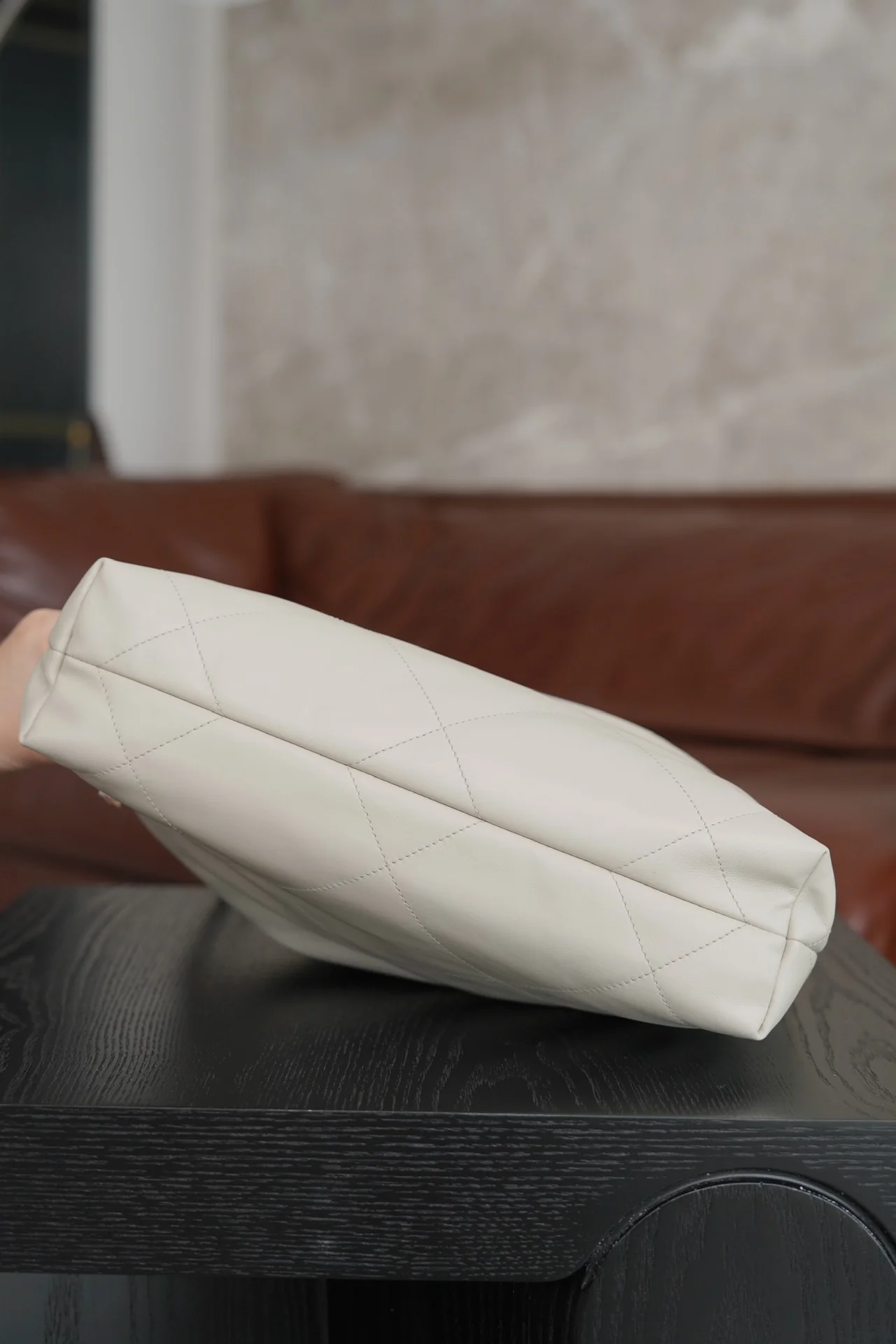 Маленькая белая сумочка Chanel с серебряной пряжкой на задней части.