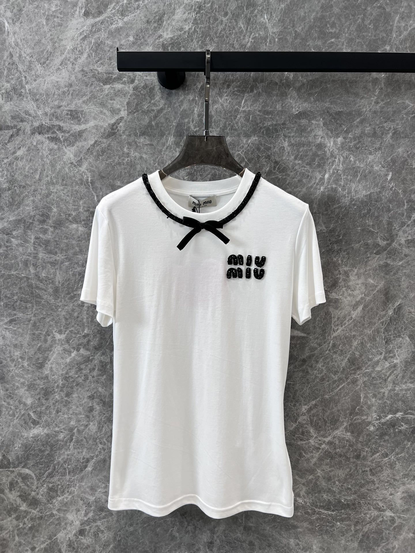 Miu Miu-2404-24 Новая модель для ранней весны: галстук ручной работы с бисером и бантом в виде буквы, футболка с коротким рукавом и круглым вырезом.