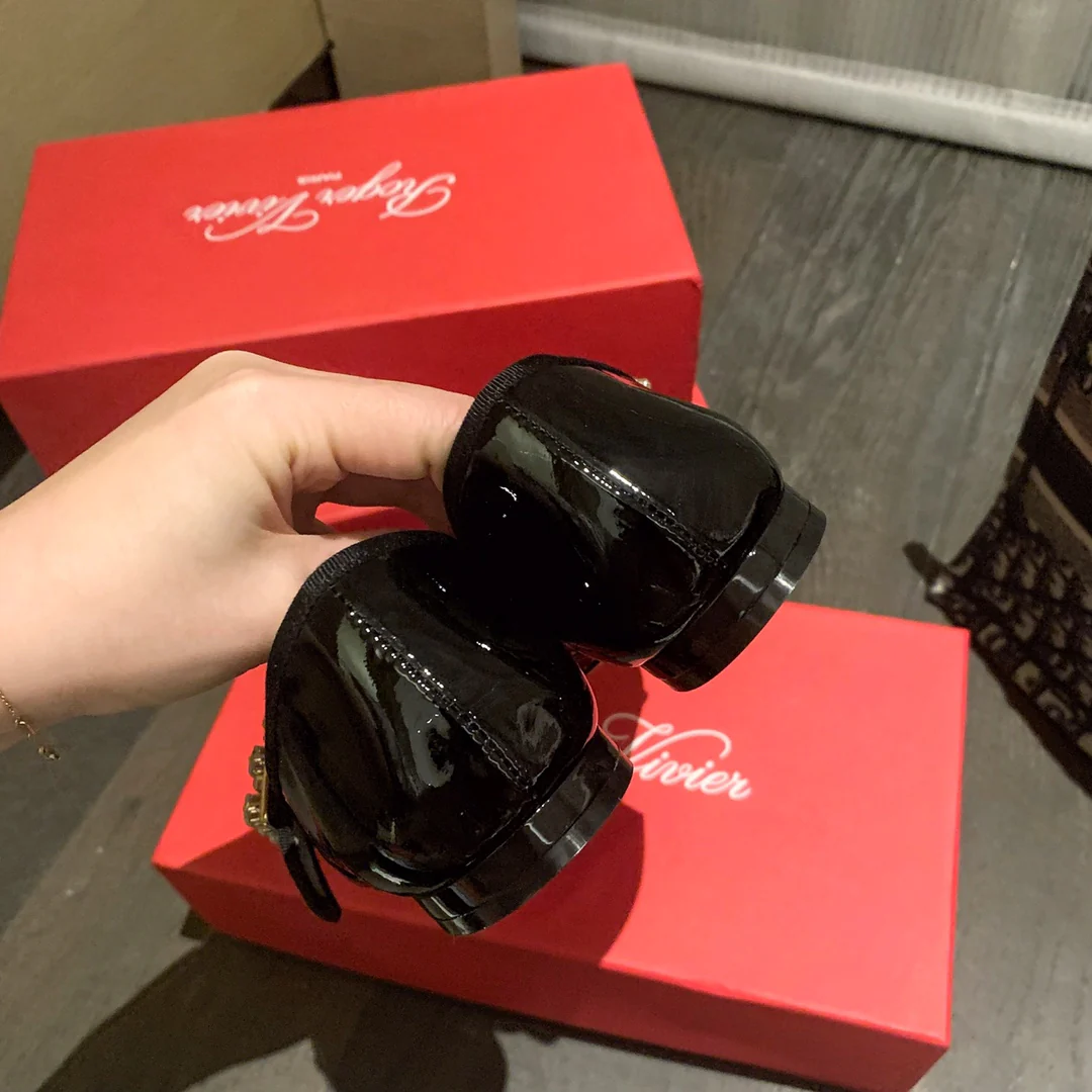 Лакированные балетки с пряжками, украшенными стразами — черные.