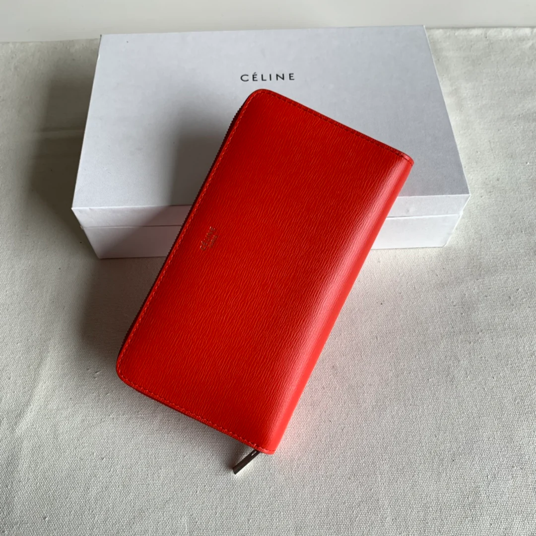 Кошелек Celine с длинной молнией — оранжево-красный узор в виде ряби на воде.