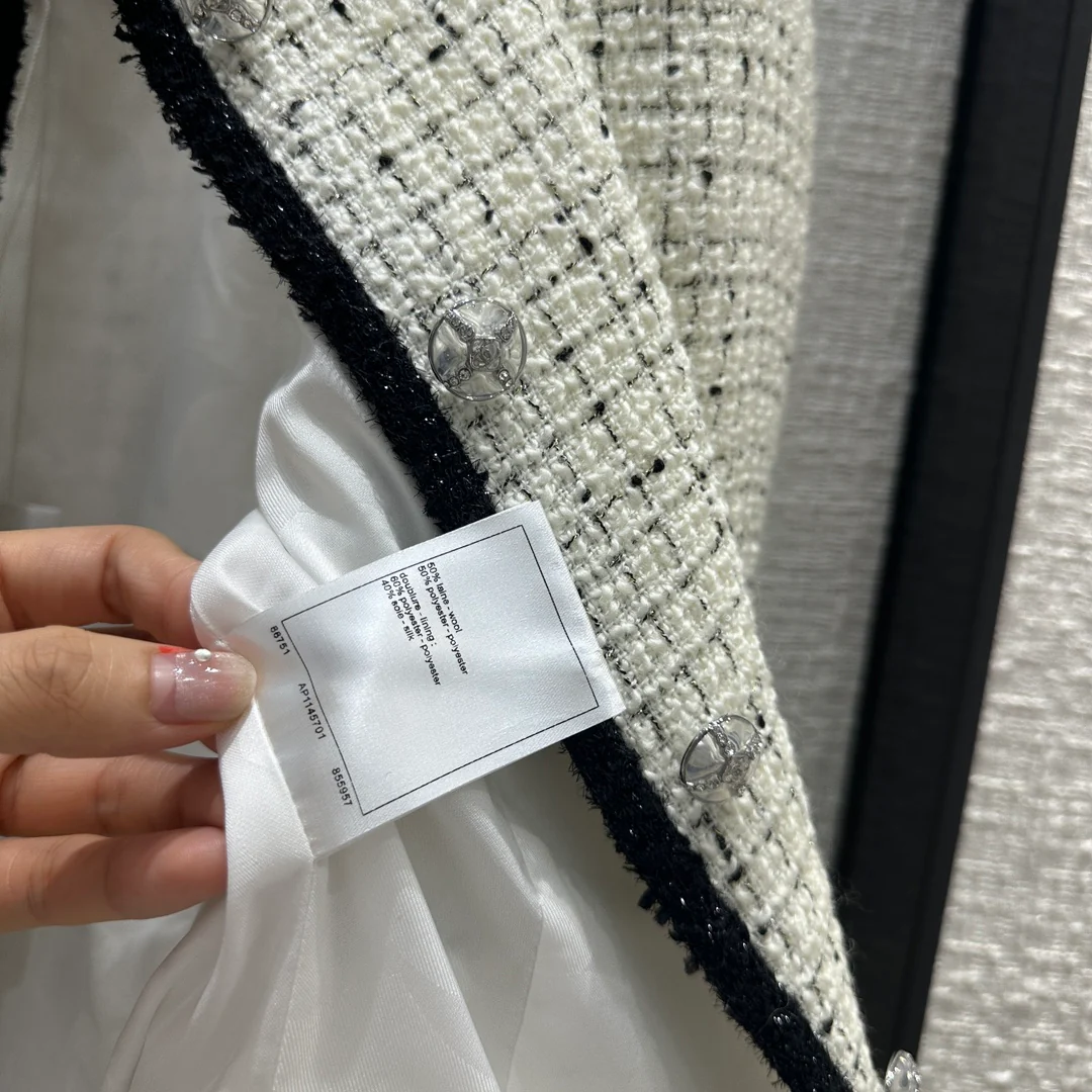 Chanel 2403 - Короткий жакет с изящной черной отделкой и блестящими деталями.