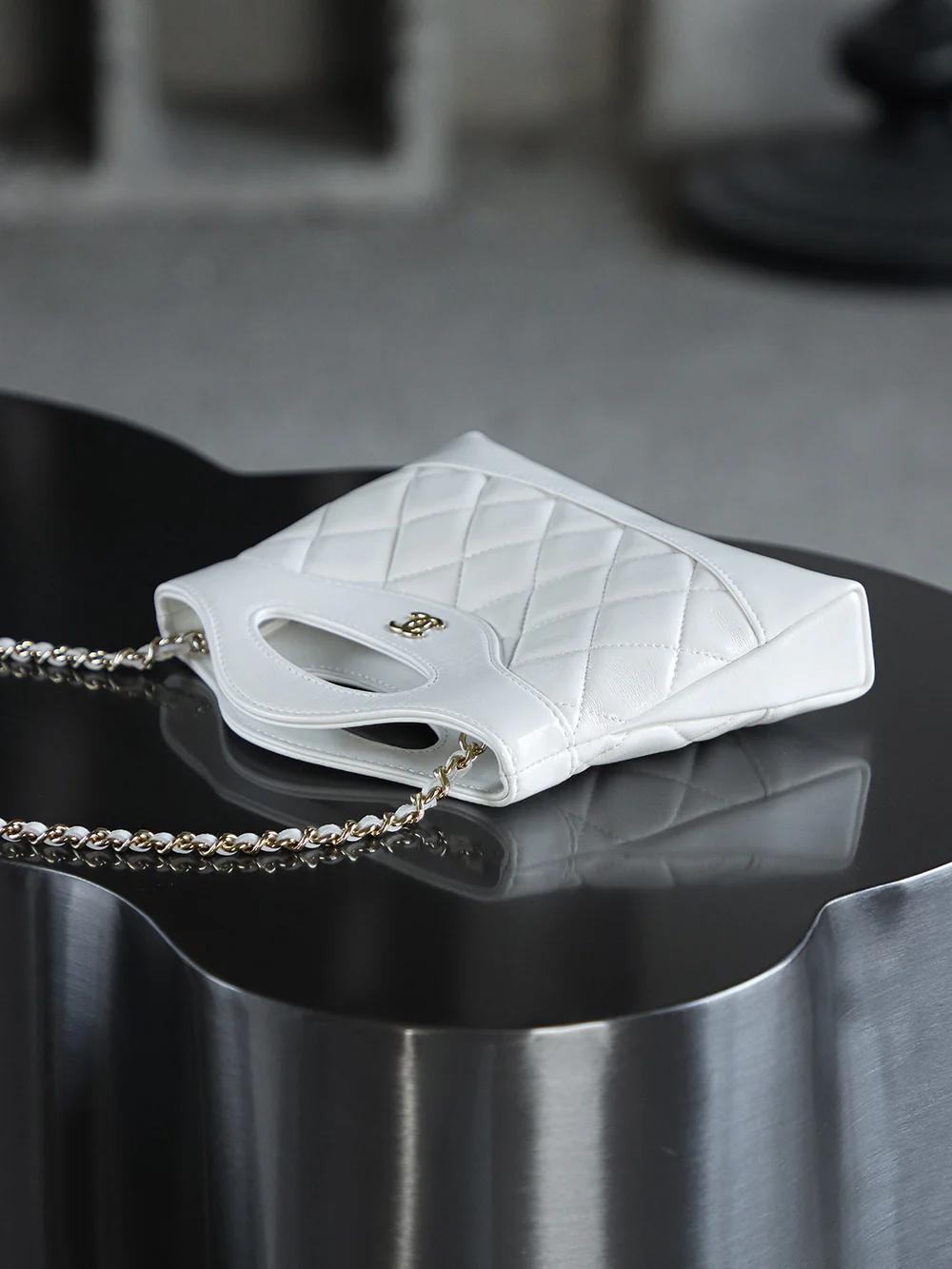 Сумка Chanel Nano 31, горизонтальный вариант, белая с пряжкой из светло-золотистого металла.