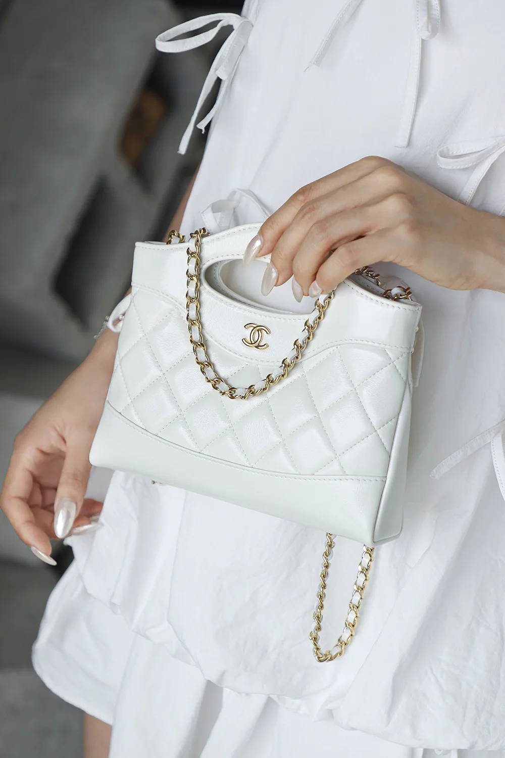 Сумка Chanel Nano 31, горизонтальный вариант, белая с пряжкой из светло-золотистого металла.
