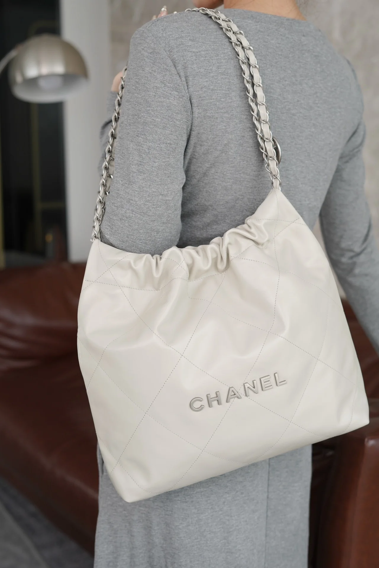 Маленькая белая сумочка Chanel с серебряной пряжкой на задней части.