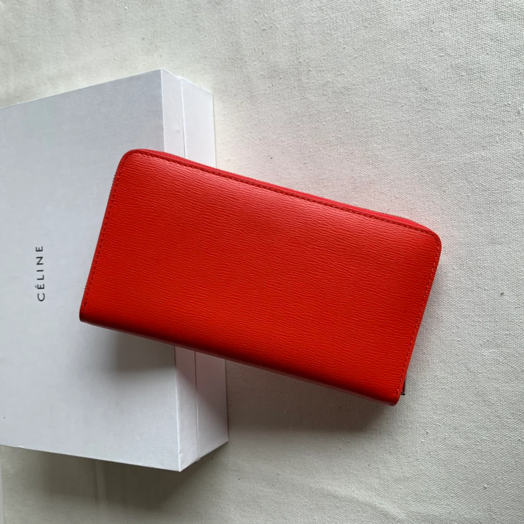 Кошелек Celine с длинной молнией — оранжево-красный узор в виде ряби на воде.