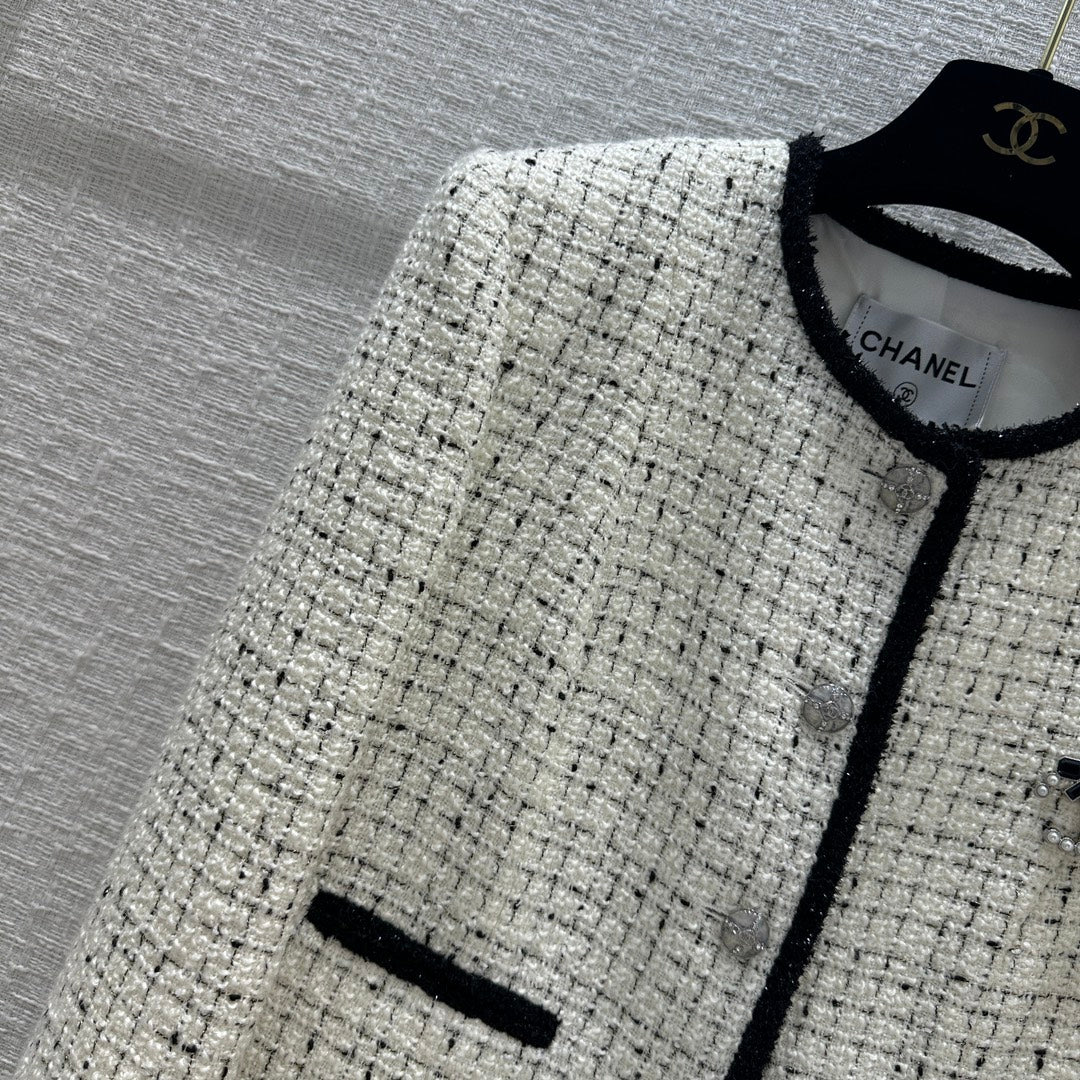 Chanel 2403 - Короткий жакет с изящной черной отделкой и блестящими деталями.