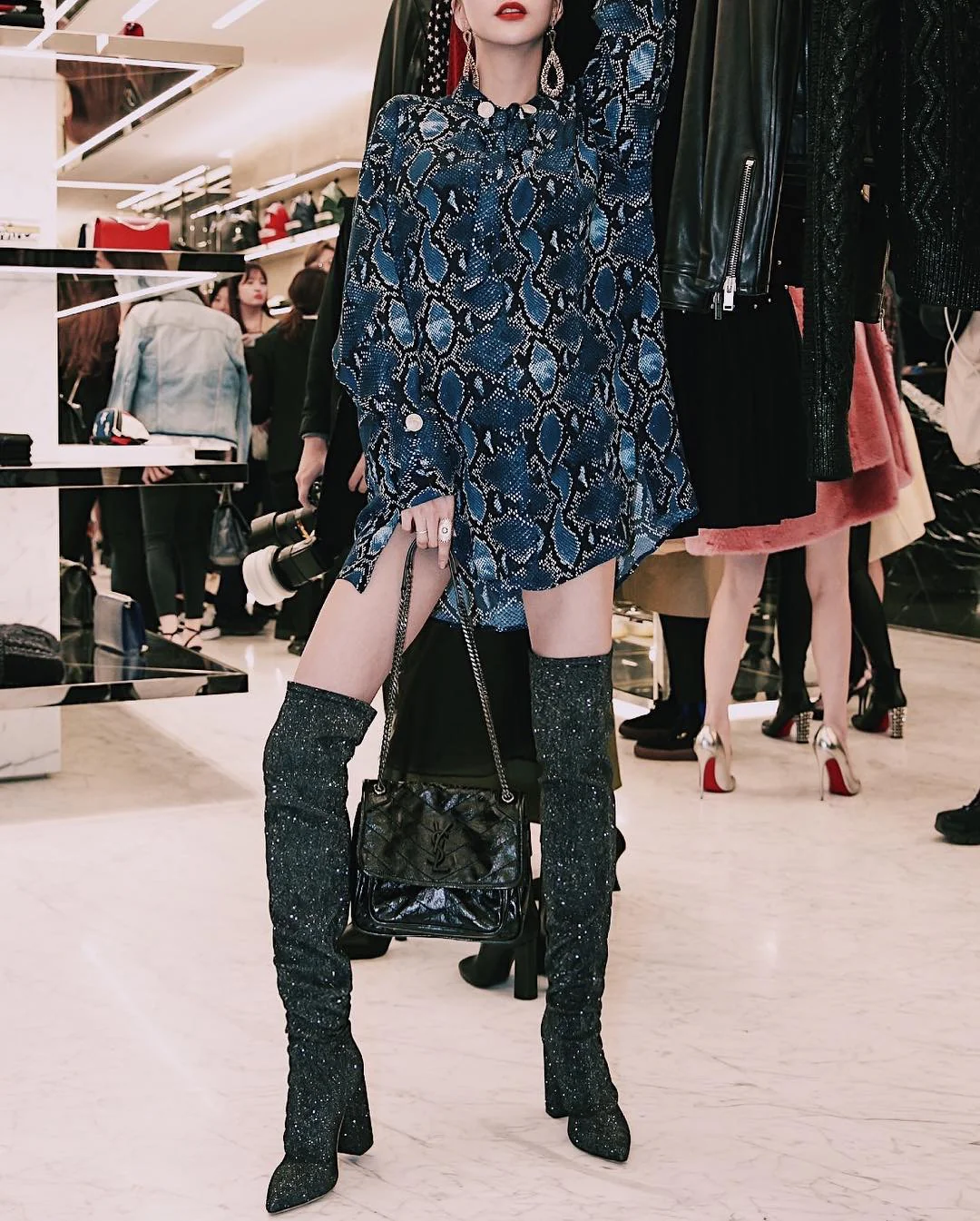 Фотография сумки YSL Niki Messenger из черной кожи, размером 22 см на теле.