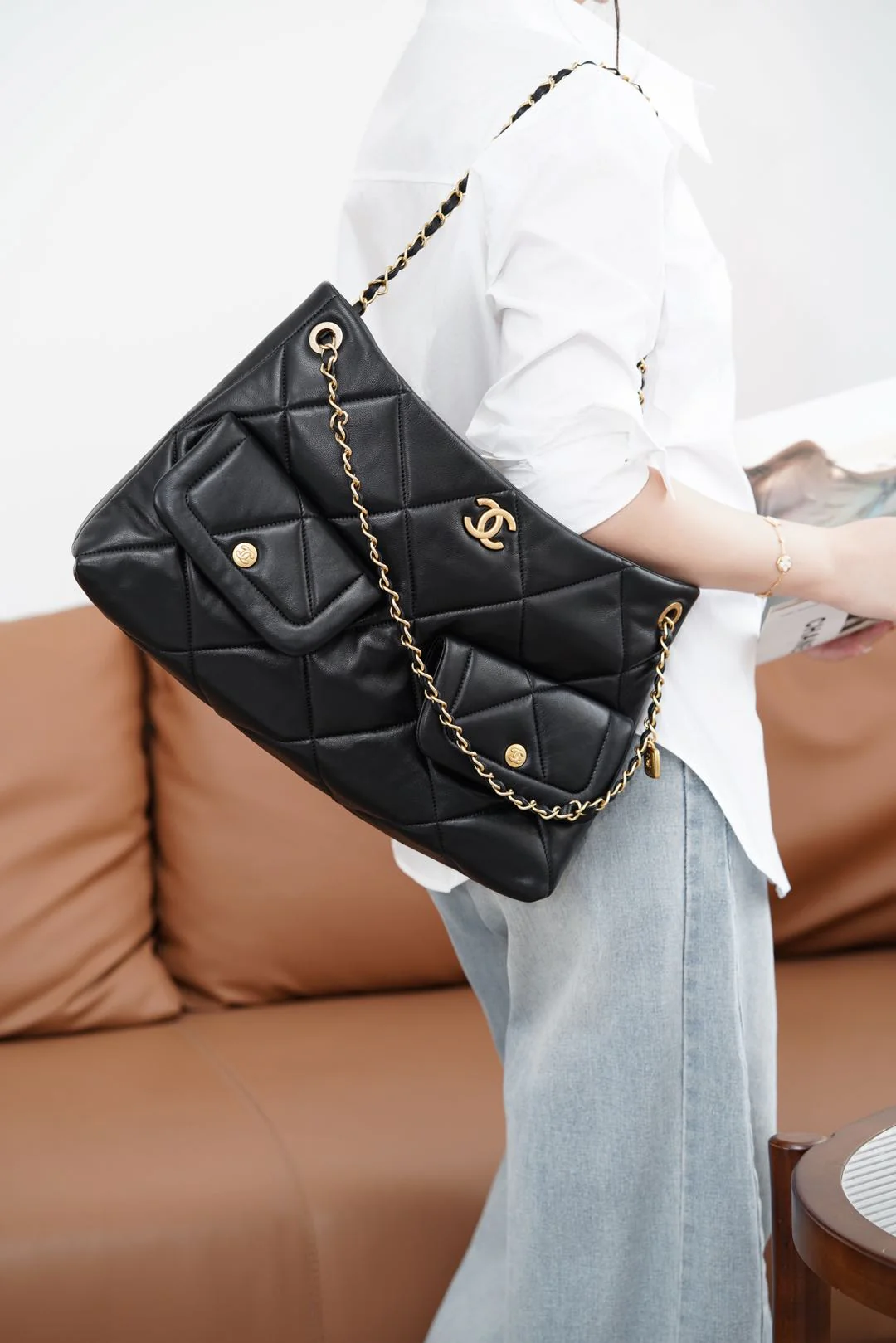 Сумка-хобо Chanel 25k — черная, из овечьей кожи, с золотой фурнитурой.