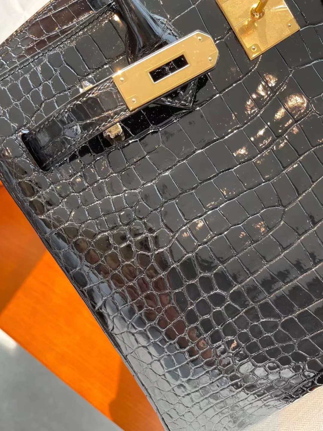 Сумка Hermes Birkin 30 из кожи аллигатора, черная, с золотой пряжкой.