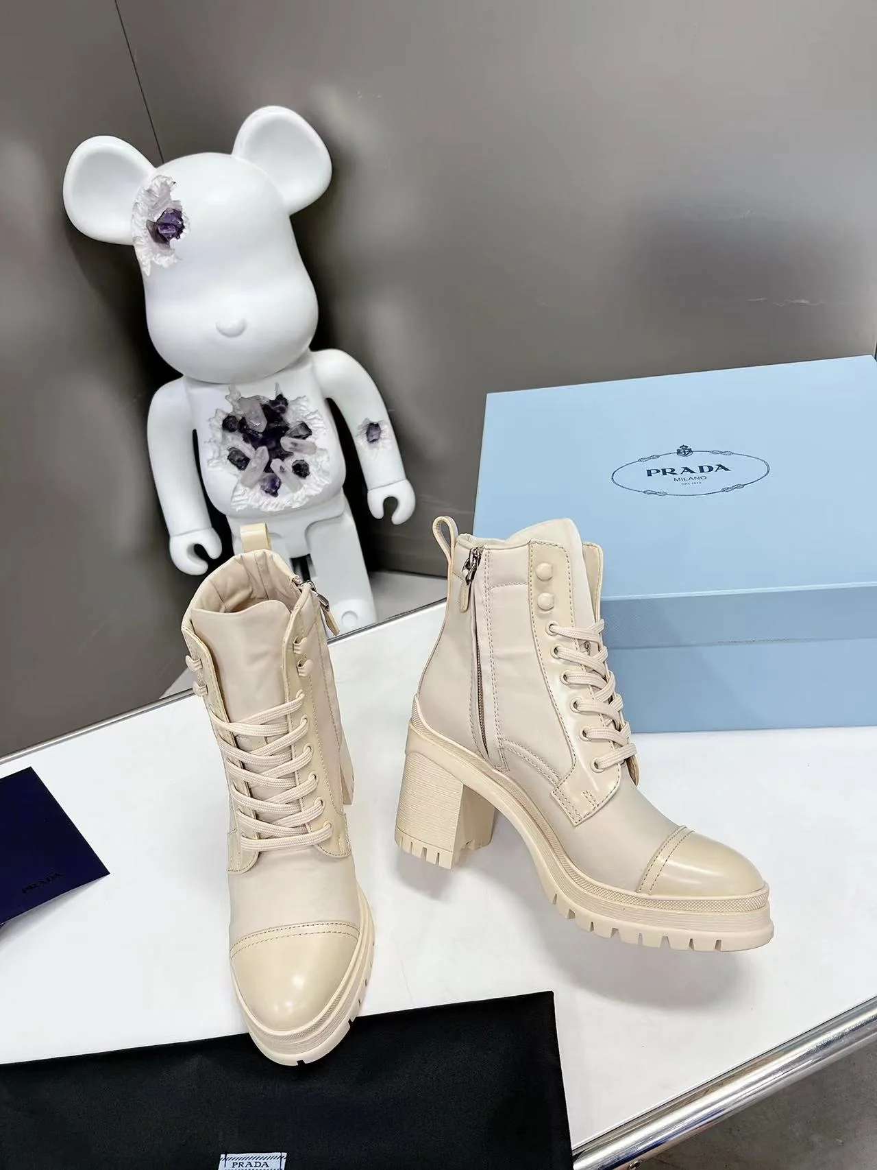 Новинка весны 2022 года от Prada: ботильоны на шнуровке и массивном каблуке — белые.