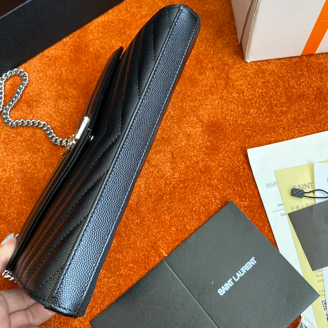 Сумка-конверт YSL с монограммой из икры — черная с серебристой фурнитурой.