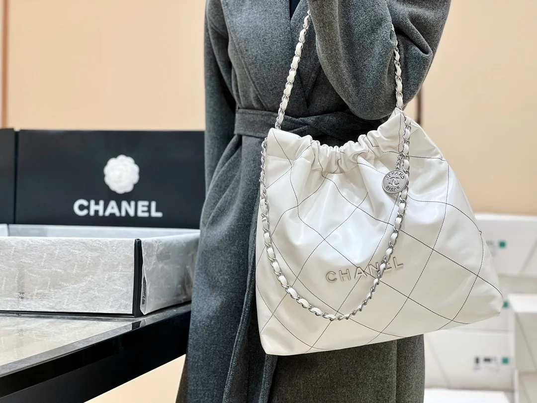 Сумка Chanel из круизной коллекции 2023 года - размер 22 - средний размер - белая с черной строчкой - на фото в ношении.