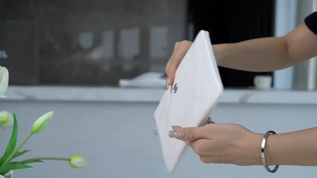 Сумочка Chanel No. 22 — маленькая, белая, серебристая.