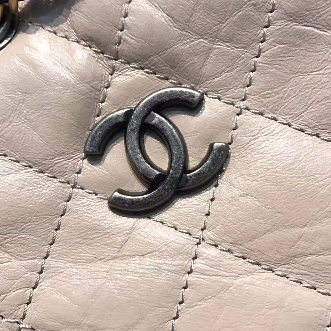 Маленький рюкзак-хобо Chanel — бежевый и черный.