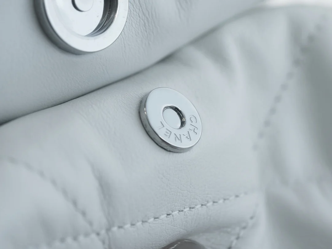 Сумочка Chanel No. 22 — маленькая, белая, серебристая.