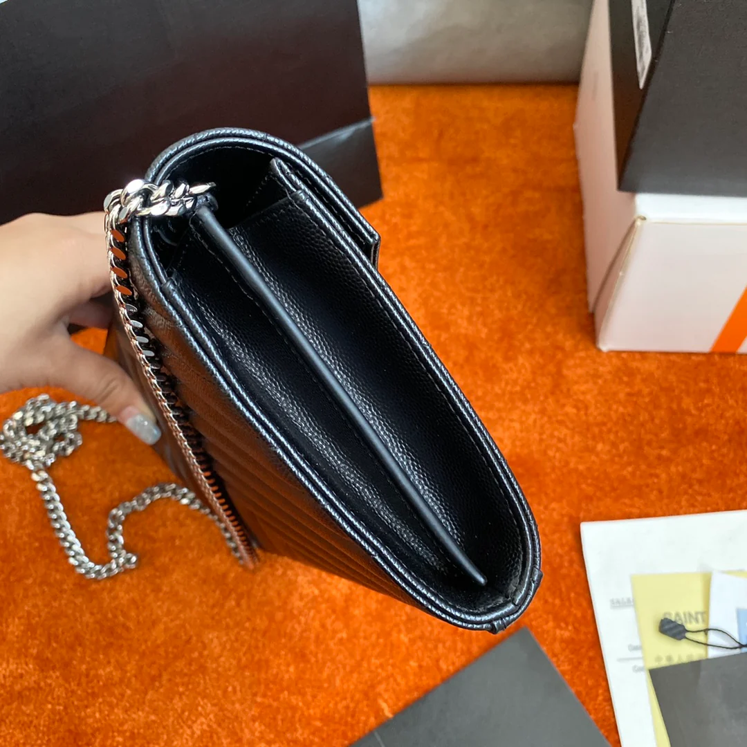 Сумка-конверт YSL с монограммой из икры — черная с серебристой фурнитурой.